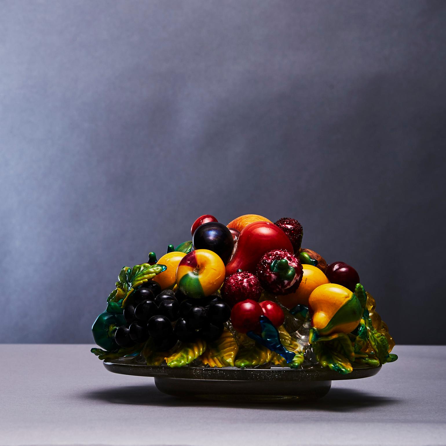 Sculpture de nature morte en verre de Murano, réalisée selon la technique du verre soufflé et appliqué.  La coupe en verre avec des fruits en polychrome aux détails complexes est réalisée par Artisti Barovier (1890-1919) vers 1919. Chaque fruit a sa