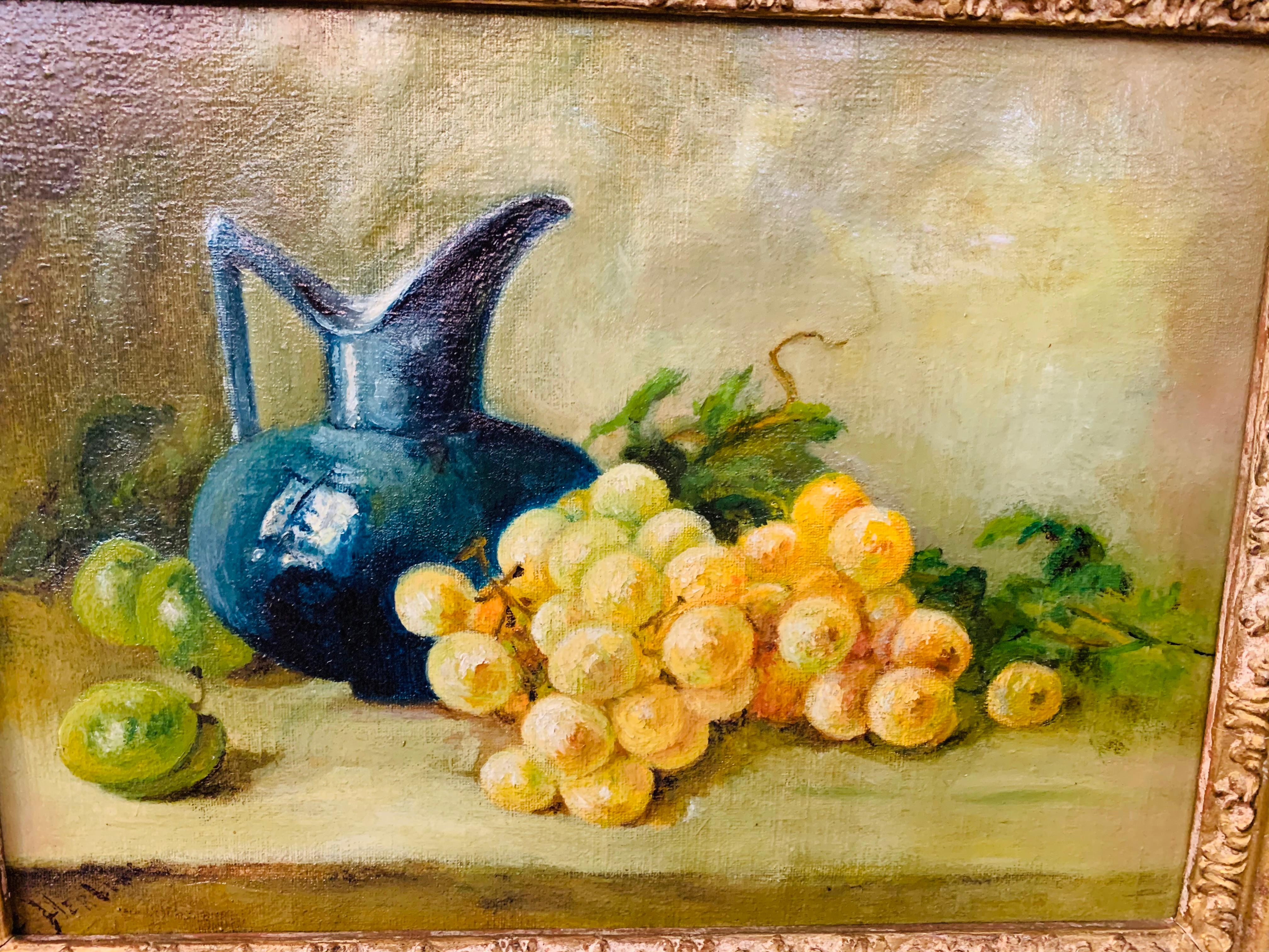 A small still life oil on canvas painting of a pitcher and grapes on a green toned background in an exquisite custom gilded frame. Unsigned. 

Dimensions: 17.5