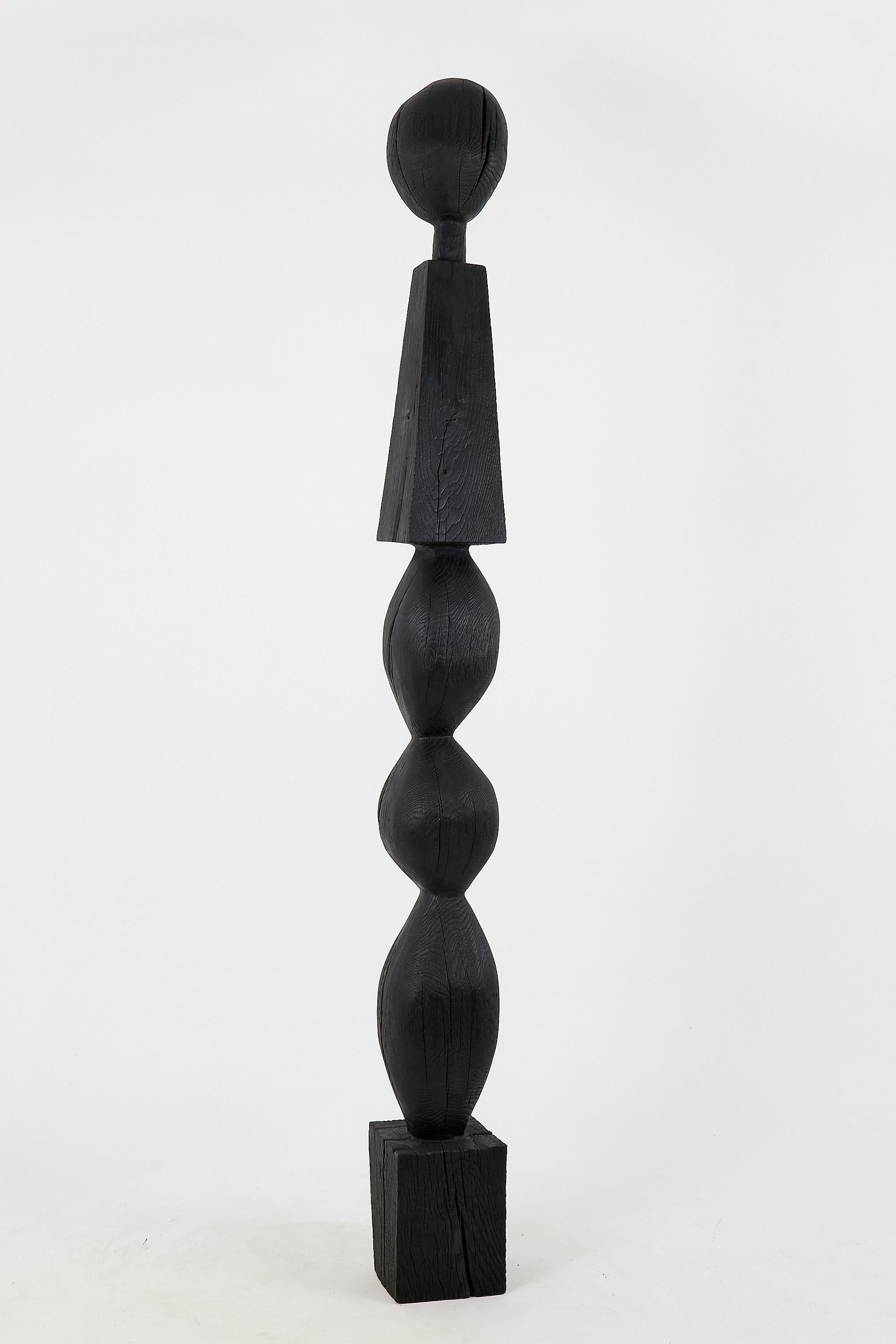 This exquisite black sculpture, made from reclaimed charred oak beams, embodies a blend of artistry and sustainability. Its design features a captivating arrangement of rounded forms that rise gracefully above a sturdy base, creating a striking