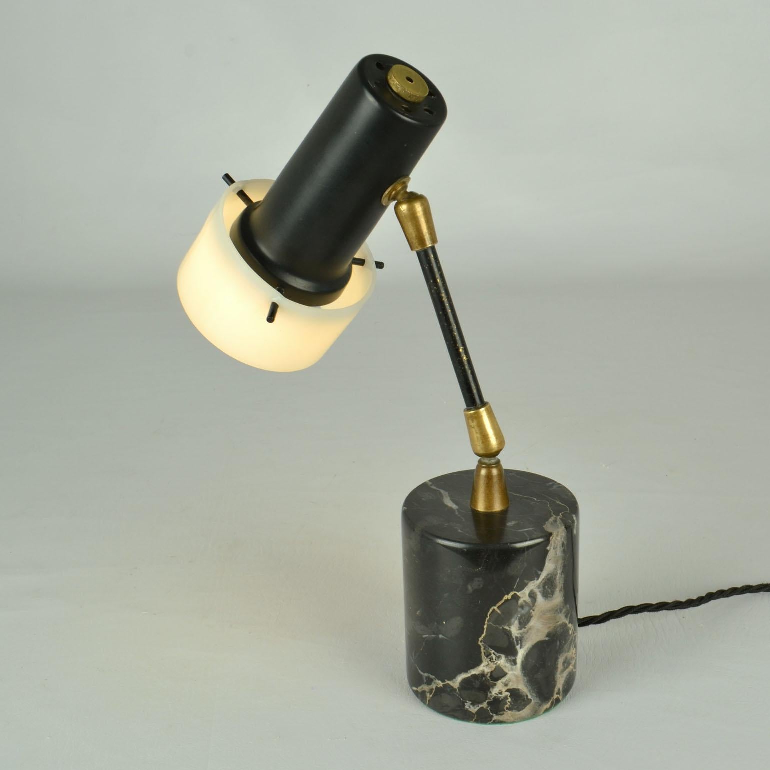 Rare petite lampe de table, fabriquée par Stilux Milano, Italie des années 1950. 
L'abat-jour de la lampe est en métal noir avec un réflecteur en plexiglas maintenu par trois broches. Le plexiglas était un matériau nouveau et innovant à l'époque.