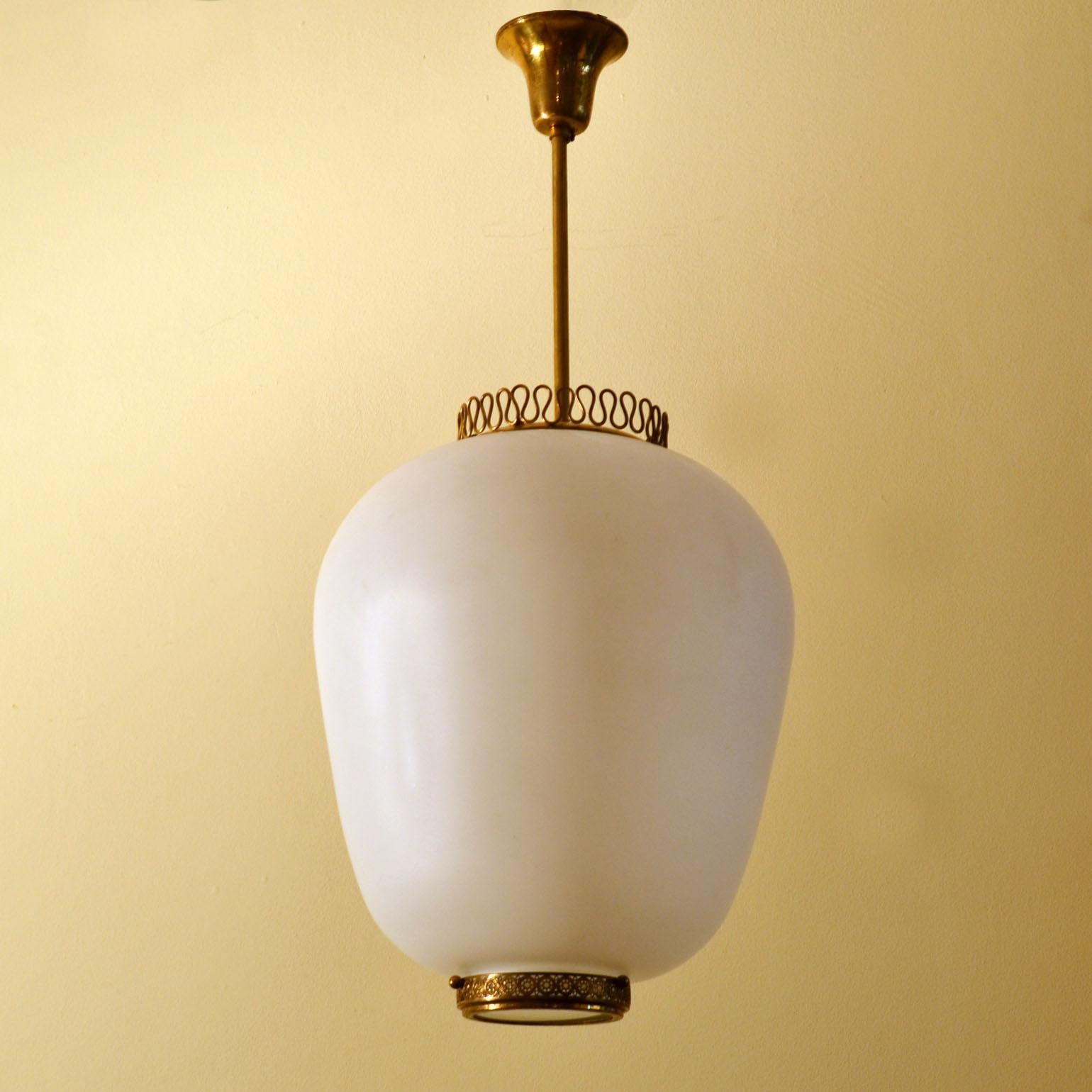 Original hand blown diffuser shade pendant lamp on brass stem by Stilnovo, 1950s, Italy. Elegant pendant lamp with large milk glass hand blown shade has a brass crown and diamond cut  glass diffuser underneath that is set in a brass frame. The lamp