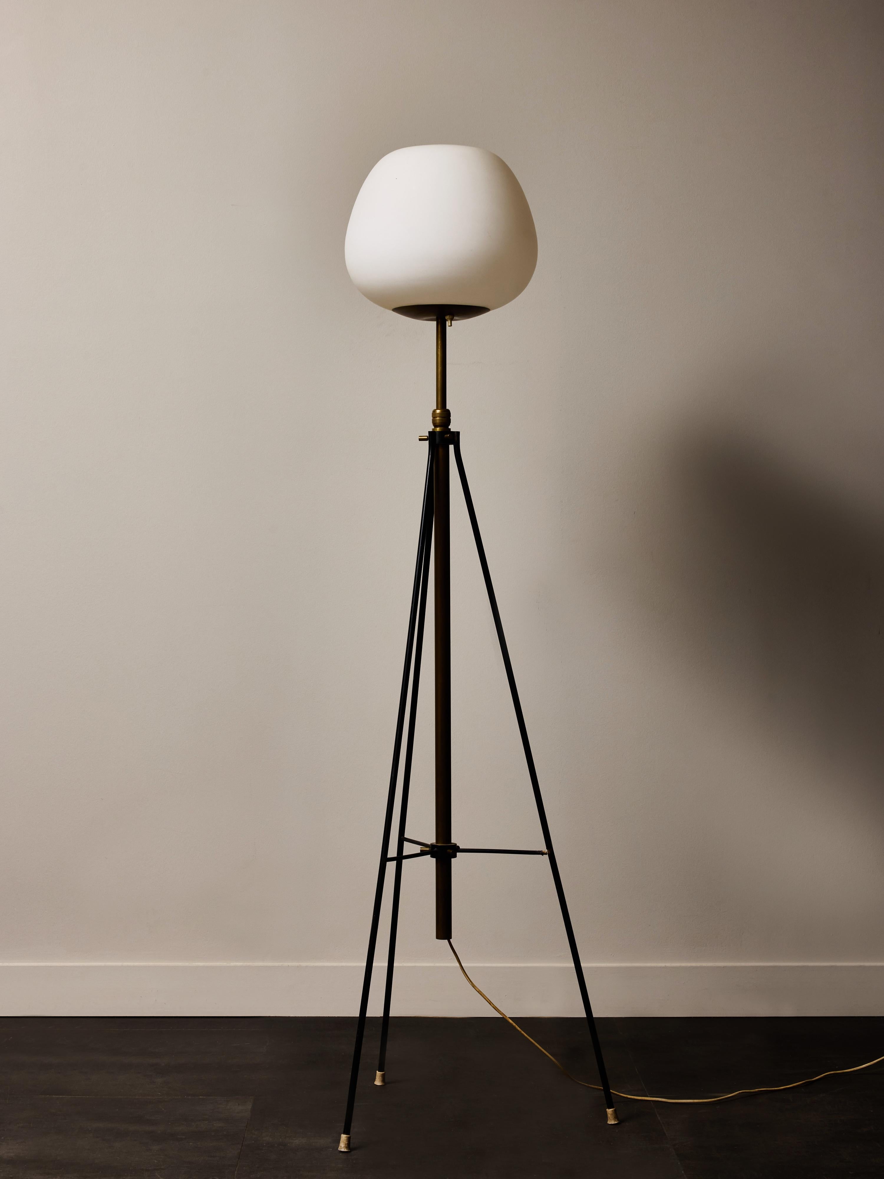 Elegant lampadaire des années 1950 de Stilnovo, présentant une combinaison raffinée de simplicité sculpturale et d'innovation fonctionnelle. La lampe repose sur un trépied élancé en métal laqué noir, ce qui lui confère à la fois légèreté visuelle et