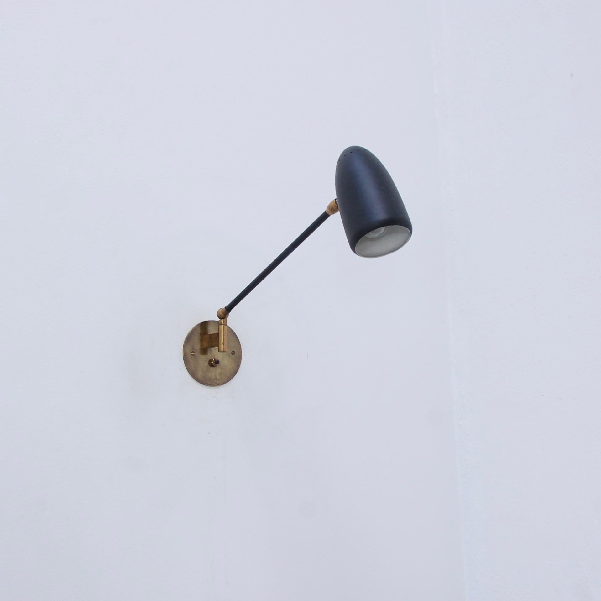 Sleek articulated directional sconce by Stilnovo of Italy. Mid-Century Modern 1950s of the period sconce. Patinated brass hardware finish and painted aluminum shade. Single E12 candelabra based socket per sconce. Currently wired for use in the US.