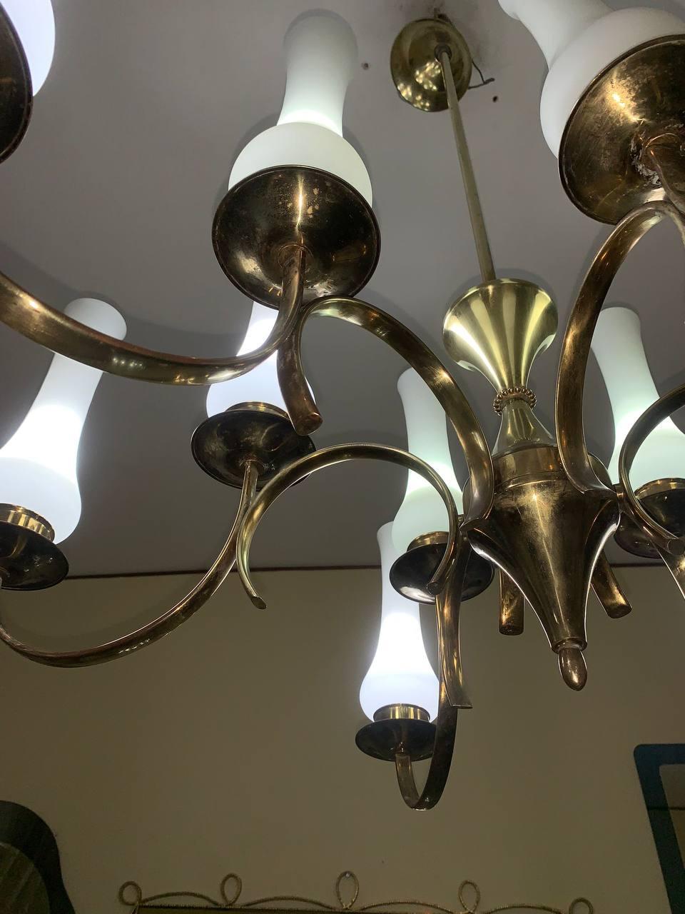 Grande lampadario originale Stilnovo in vetro opalino e ottone del 1950. The frame with central red insert, opaline Murano glass inverted lampshades with gold brass frame, clear.
Diffusers that are supported by the springs that engage the opal