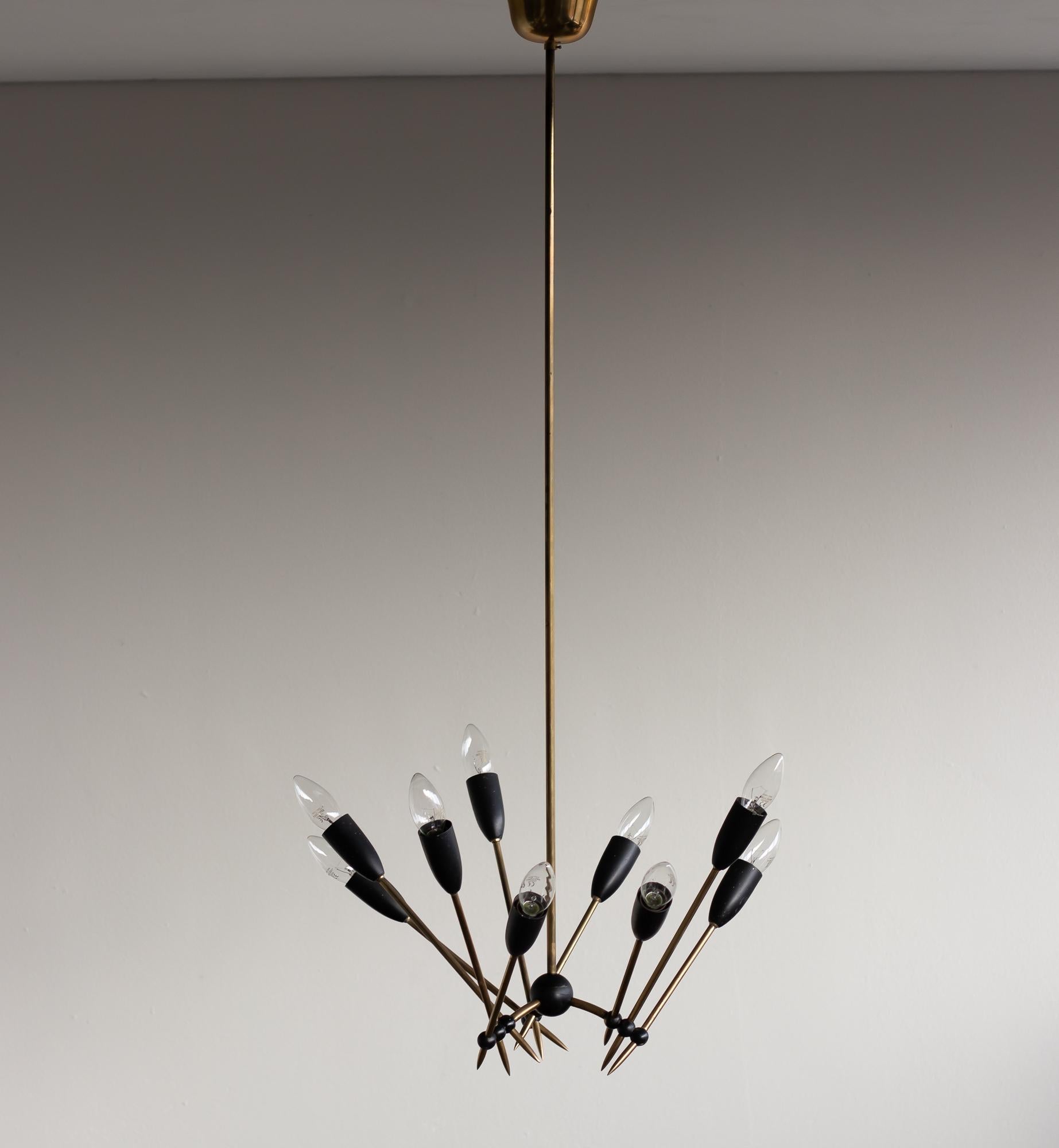 Very elegant chandelier with nine lights. Frame and canopy in brass, ball joints in black enameled brass.
Great vintage 1960s period piece, rewired for use in the USA.

Stilnovo, an influential Italian design manufacturer, emerged in the mid-20th