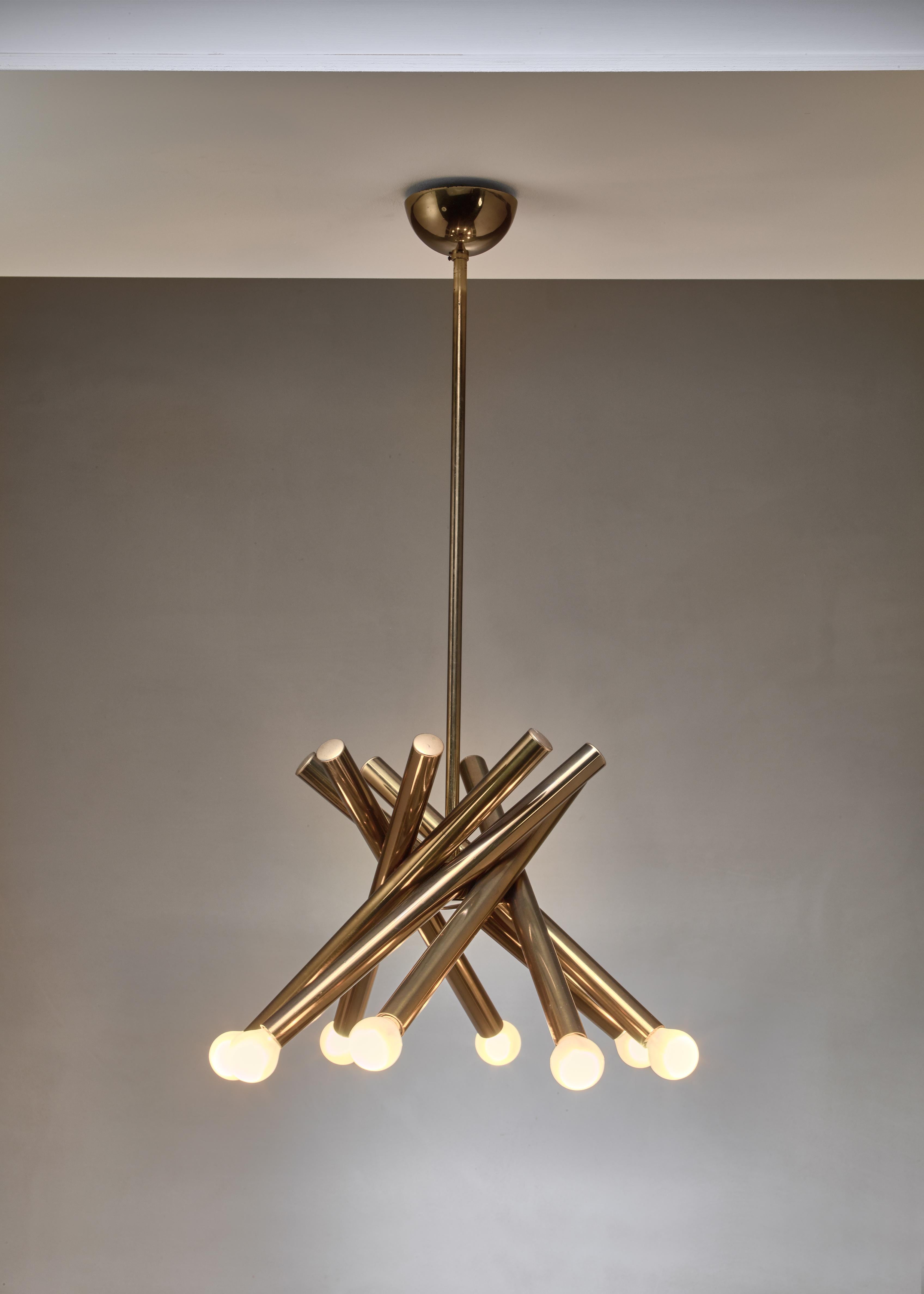 A brass Stilnovo chandelier with eight arms with a light bulb each. The angle of the arms and, with that, the width of the chandelier can be adjusted manually. The total drop of the lamp is 82 cm.