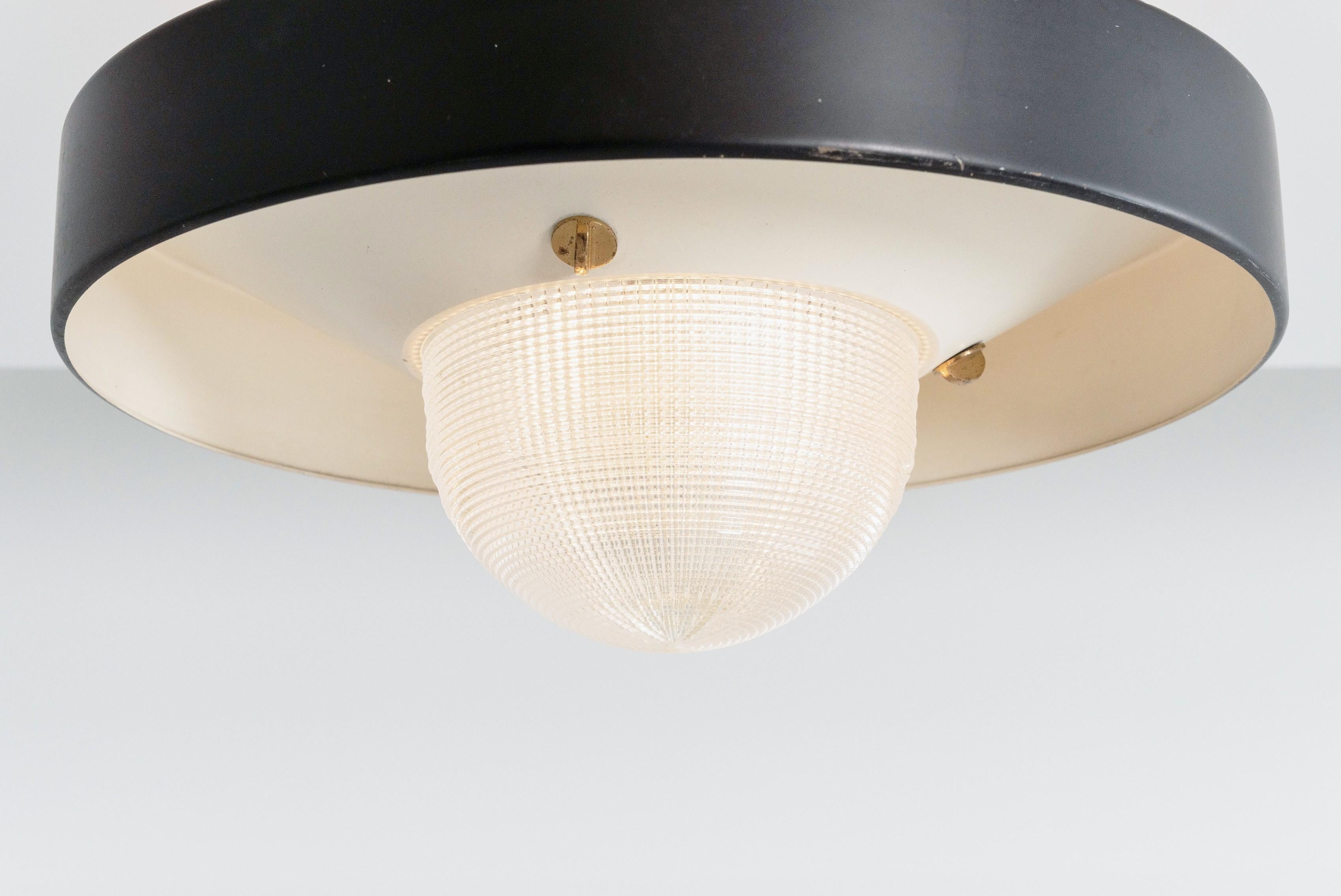 Stilnovo ceiling lamp in holophane glass, produced in Italy in 1955. The overall condition of the lamp is in very good and original condition, with some beautiful patina on the aluminum en brass parts. The Stilnovo sticker is still present on the