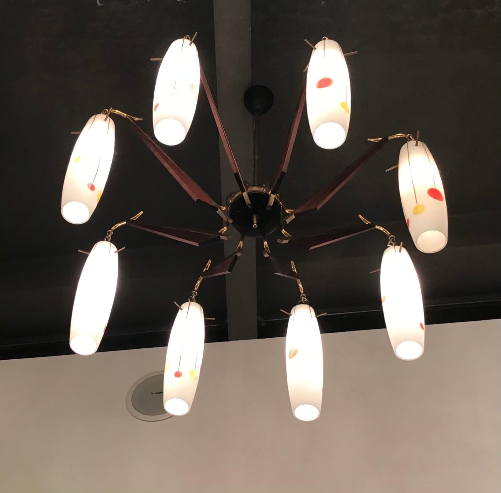 Stilnovo -Particolare lampadario a 8 luci, con vetri bianchi dipinti a mano con motivi geometrici in rosso, giallo e nero, colori tipici degli anni 50 .
Perfetto stato di conservazione 