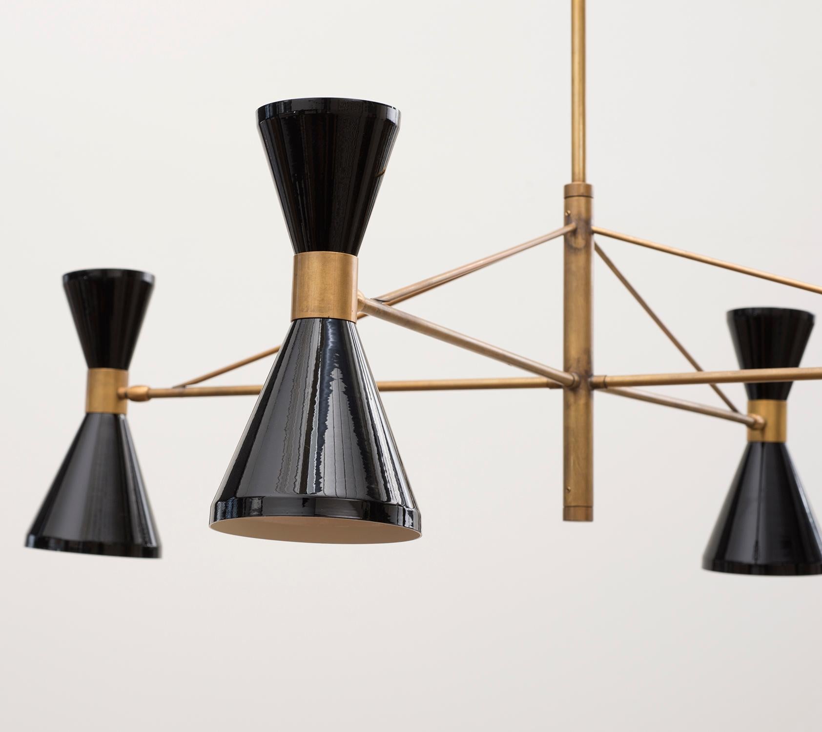 A handsome, elemental Italian chandelier with brass arms and shaft and four black-lacquered diabolo lamps, 1950s.