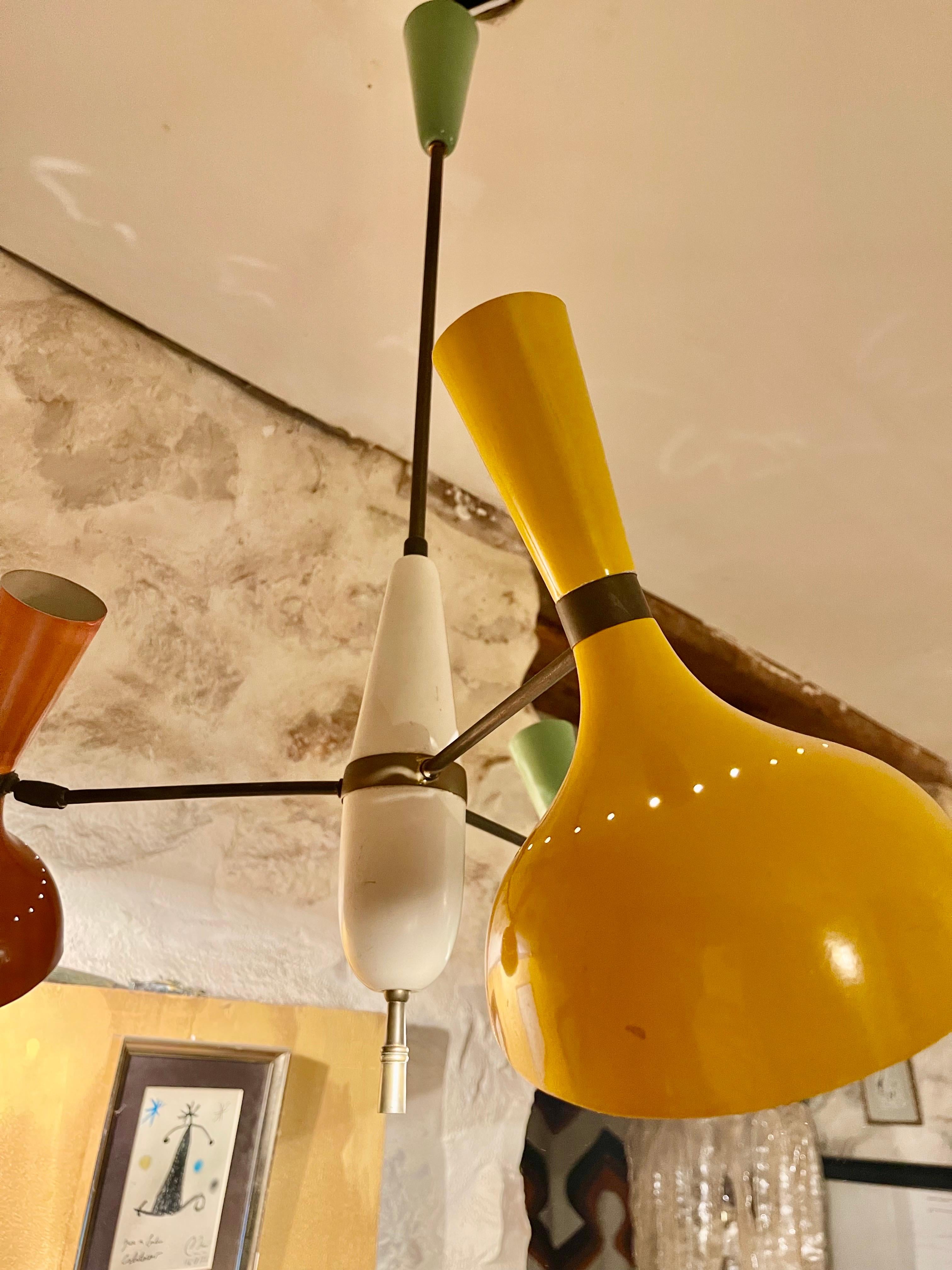 Lustre exceptionnel de Stilnovo. Conçu et fabriqué en Italie, vers les années 1950.
Luminaire multicolore à trois ombres en jaune, orange foncé et vert sarcelle. Lourde mais belle patine sur toutes les facettes.
Chaque abat-jour est équipé d'une