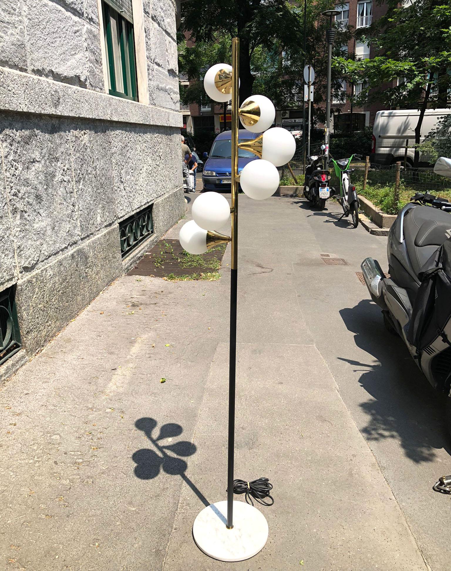 Elegant floor lamp inspired by a Stilnovo design from the 1950s, fine Italian current production manufacture.
Round white marble, with slight black streaks, in the centre of the base we see a vertical stem - black and gold brass that holds 6 lights,