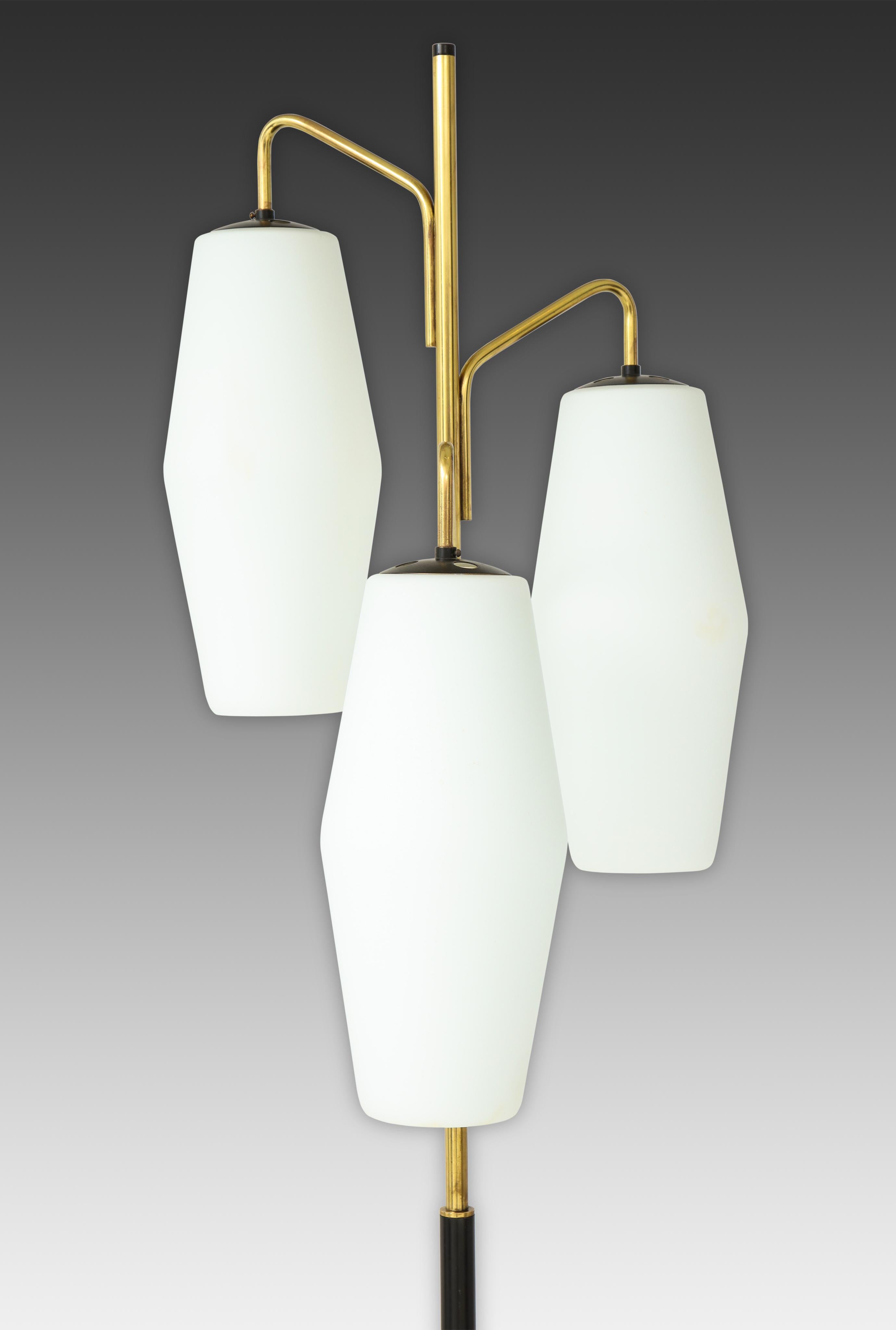 Lampadaire Stilnovo avec trois abat-jours lanternes en verre opalin suspendus à des bras en laque dorée et une tige émaillée noire se terminant sur une base en marbre de Carrare, Italie, années 1960. 
Nouvellement recâblé aux normes