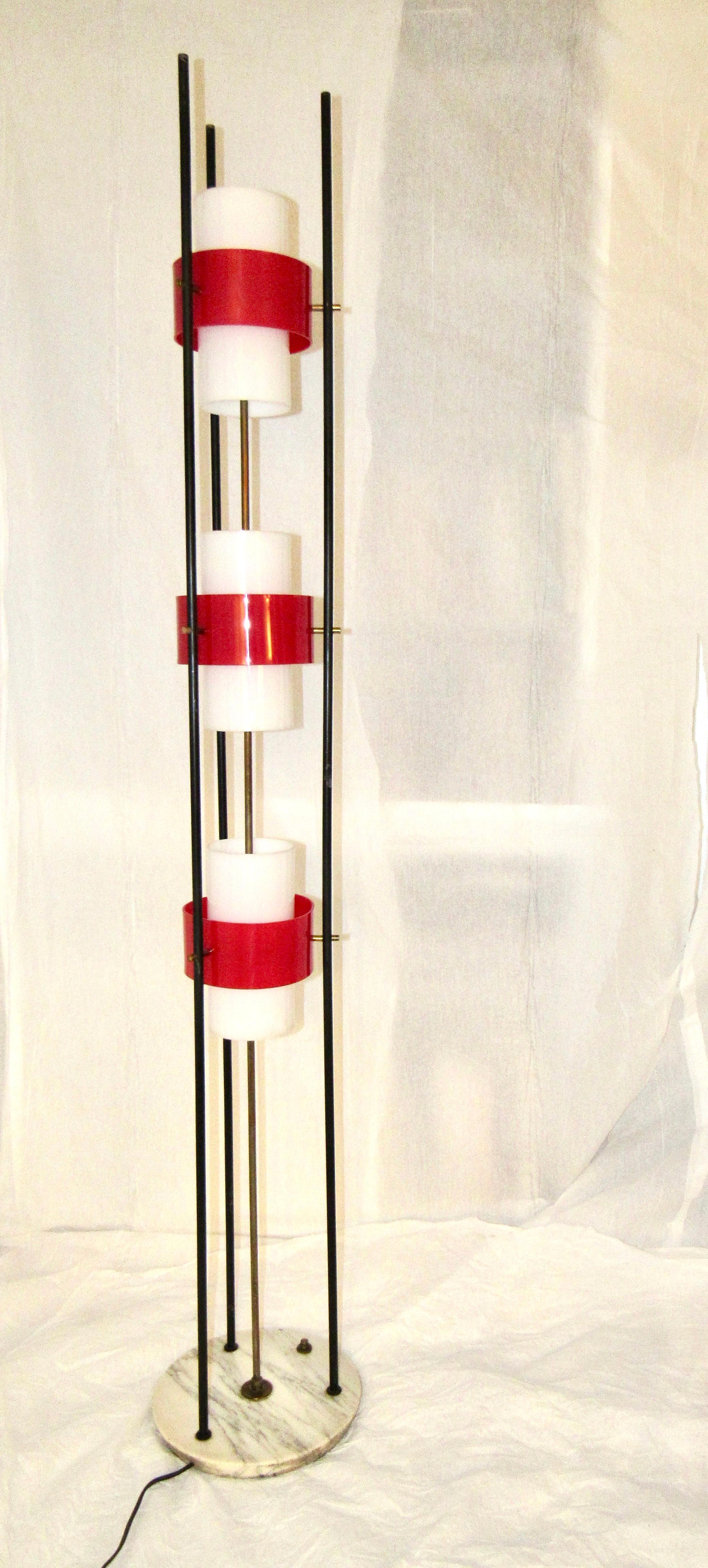 Stilnovo floor lamp, Italy, 1960 with a marble base, three black lacquered rods, red and white acrylic plexi shades and brass details. 
The lamp is in very good condition and has been professionally rewired.. 

 