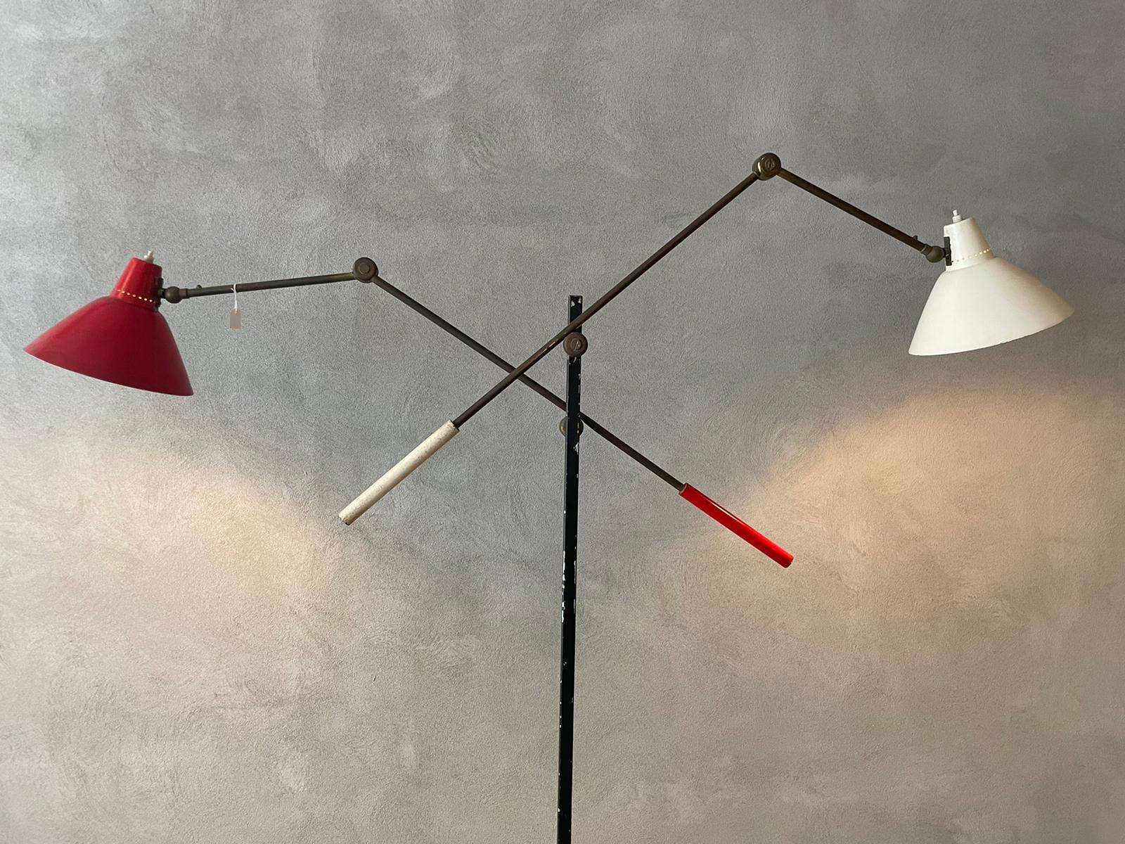 Floor lamp manufactured by Stilnovo in Italy, 1955.
The floor lamp has a circular white marble base, black lacquered metal steam.
The floor lamp has two brass arms and one white and one red lampshades that can be adjust to various positions and