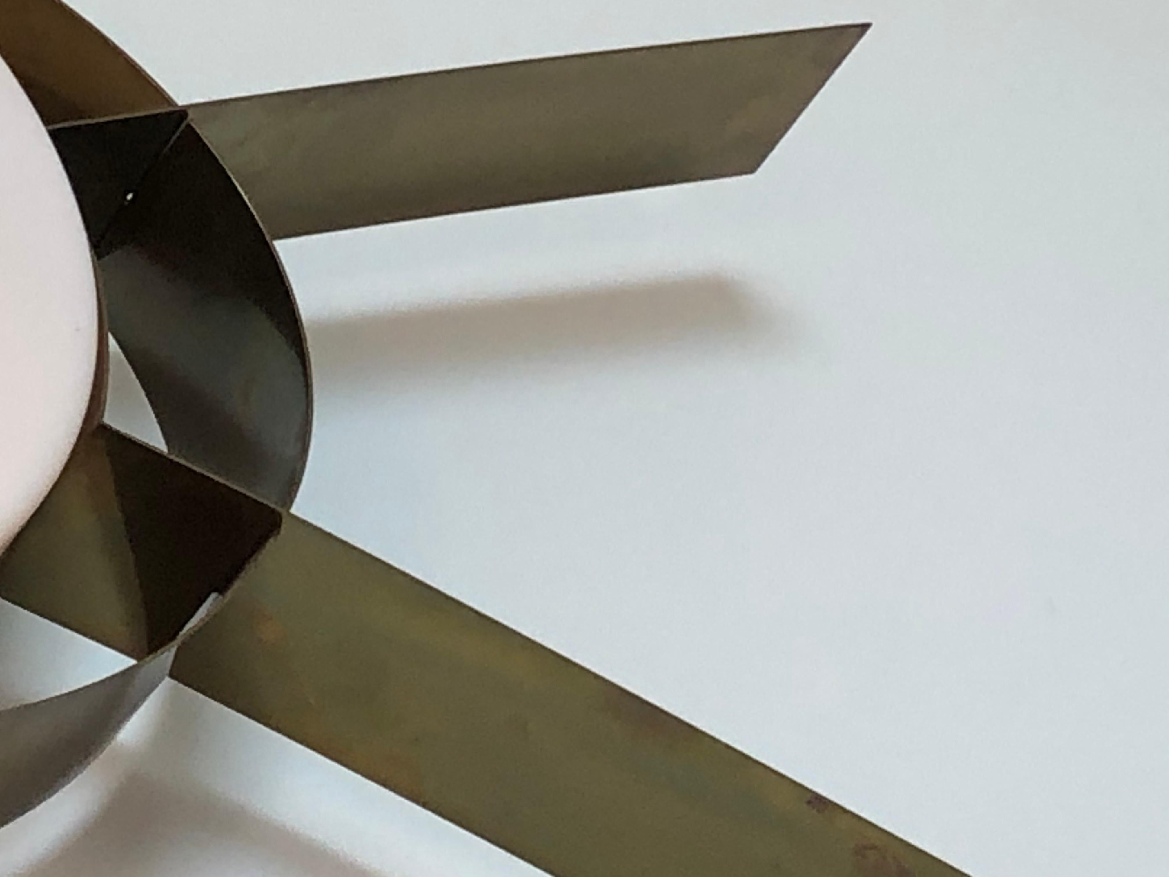 Applique dalle dimensioni imponenti, con struttura ovale in ottone con elementi trasversali in ottone e luce centrale rotonda con paralume in perspex bianco. Può essere appeso in orizzontale o in verticale.