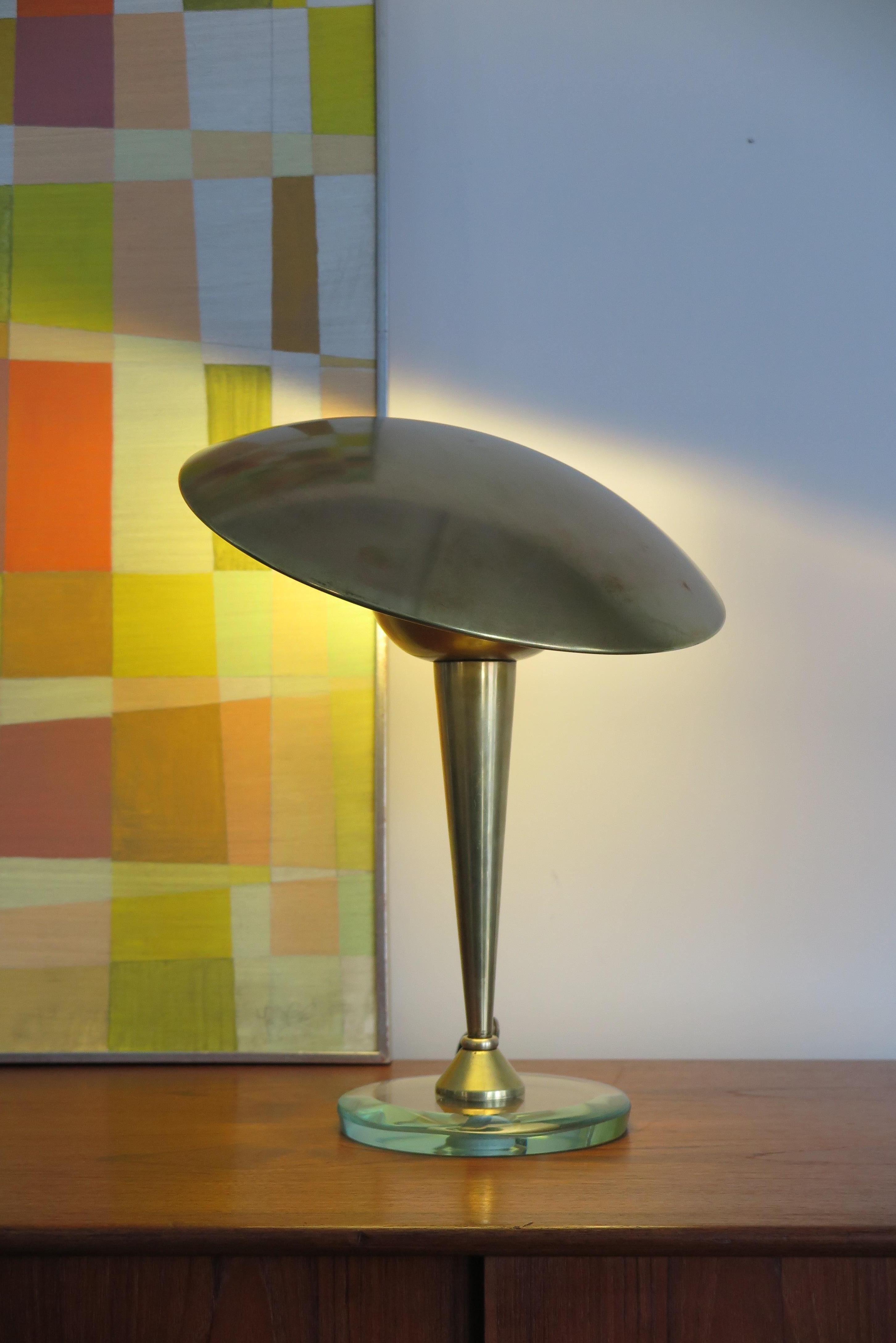 1950s Italian brass Stilnovo (attributed) table or desk lamp with bevelled crystal base and adjustable round brass shade.

Please note that the lamps is original of the period and this shows normal signs of age and use.