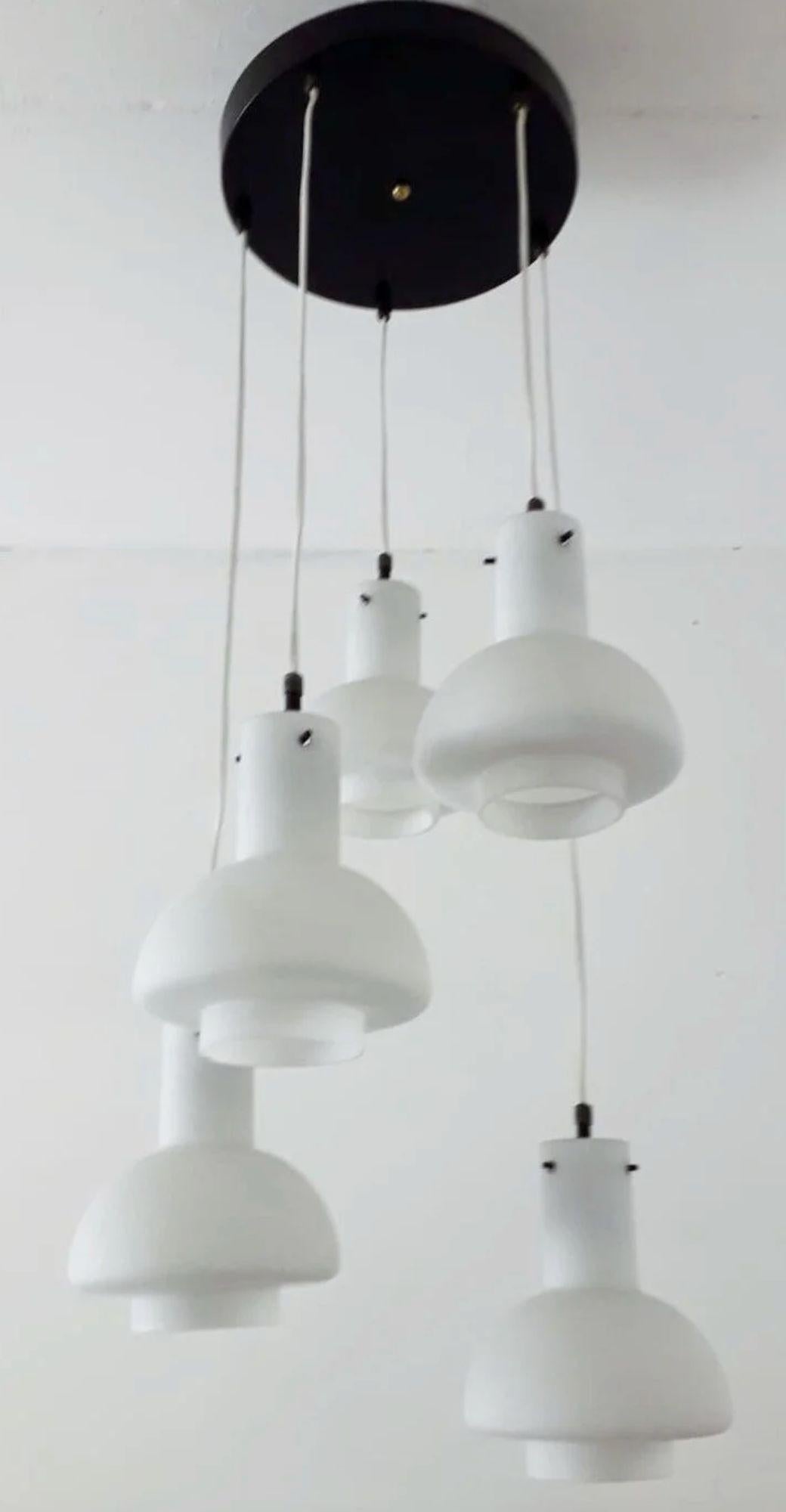 Luminaire suspendu encastré original de Stilnovo, conçu et fabriqué en Italie vers les années 1960. Cette élégante pièce du milieu du siècle comporte cinq lampes suspendues réglables en hauteur, chacune dotée d'un abat-jour sculptural en verre