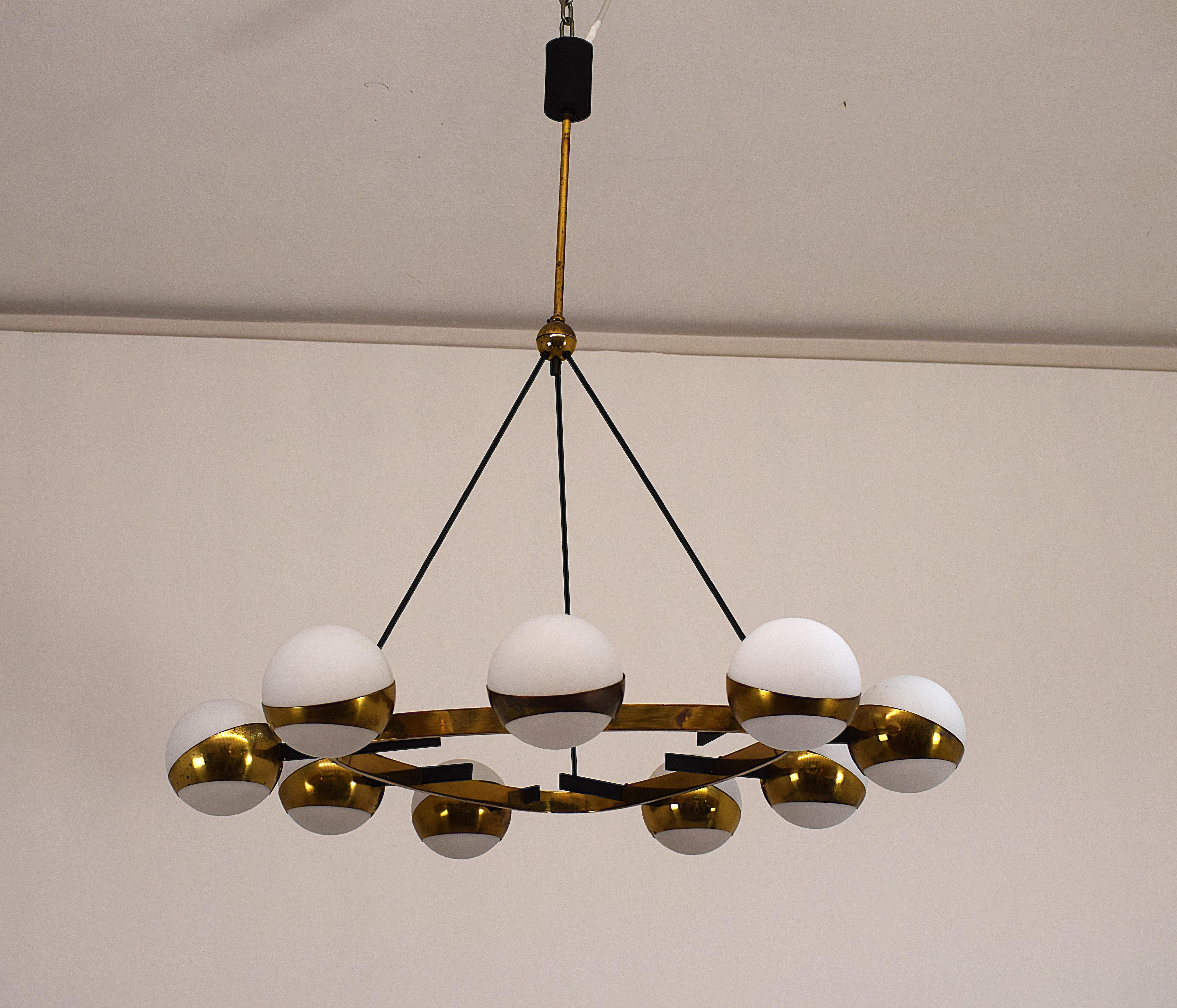 Elegante lampadario Stilnovo originale degli anni ’50, realizzato in Italia. Questo raro pezzo di design mid-century  unisce l’eleganza dell’ottone al rigore del metallo e alla morbidezza del vetro opalino satinato, creando un’atmosfera calda e
