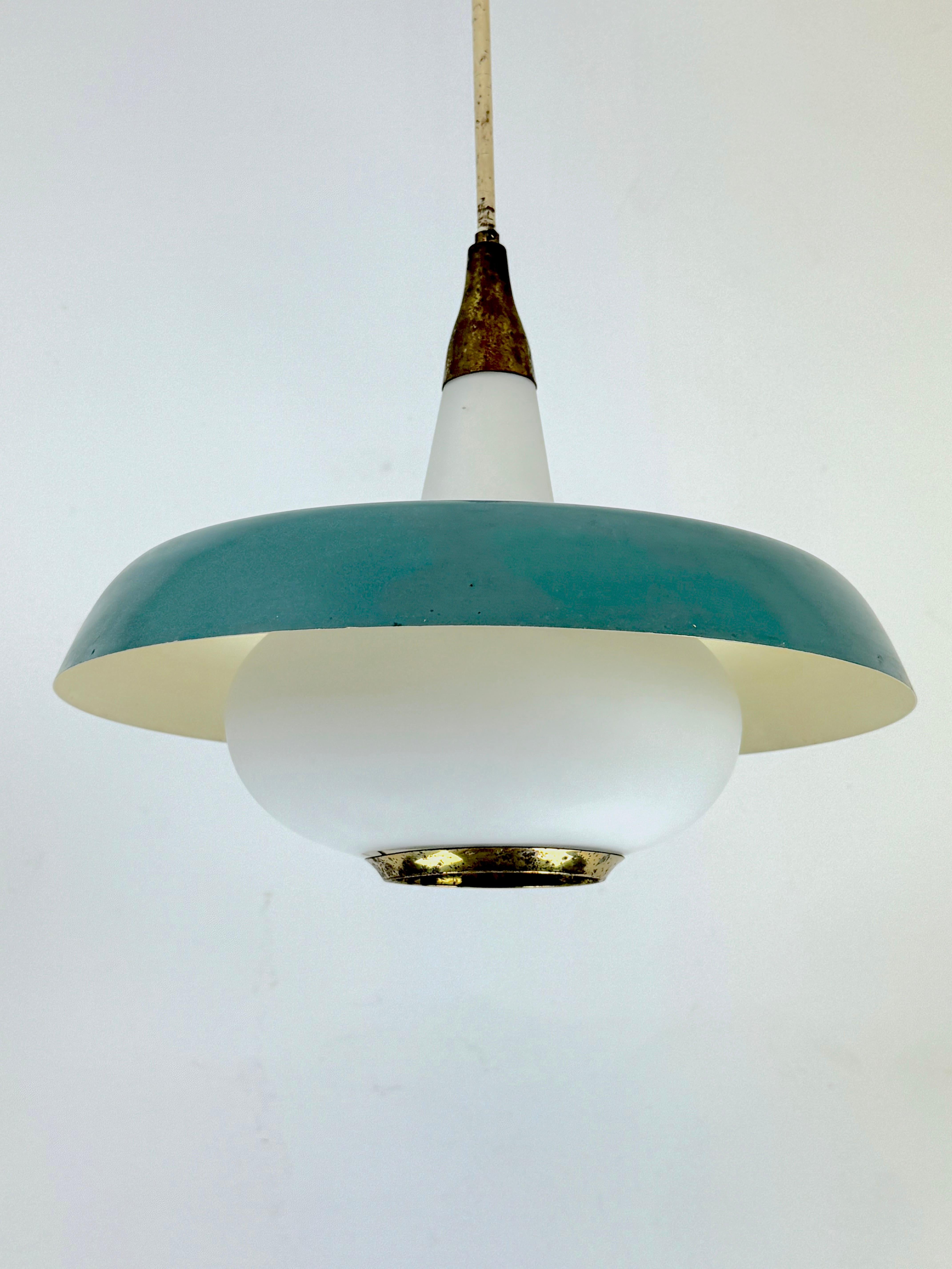 This exquisite chandelier is a classic piece from the renowned Italian designer Stilnovo, crafted in the 1950s. The chandelier features a stunning combination of brass, opaline glass, and lacquer, reflecting the sophisticated and innovative design