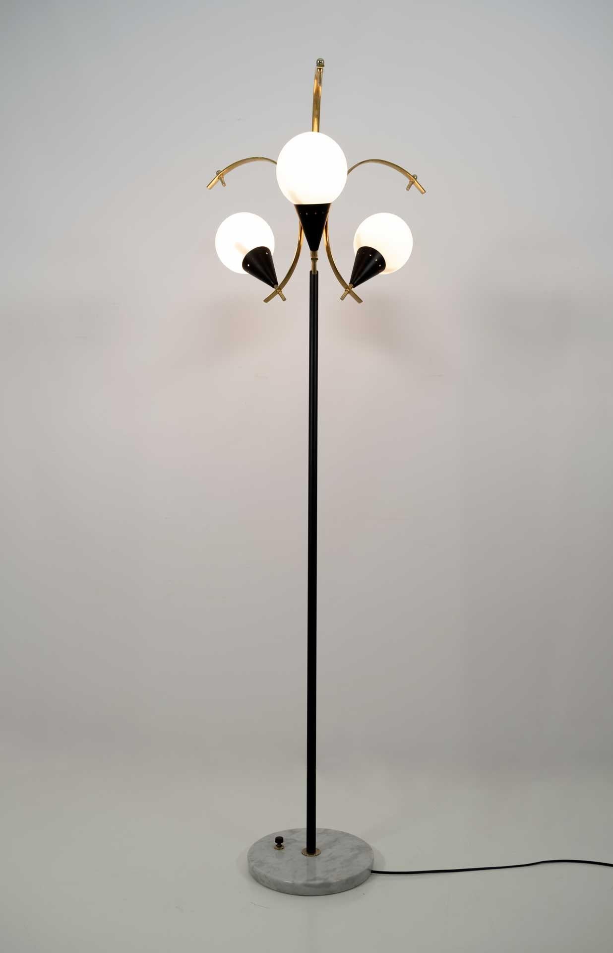 Lampadaire en laiton poli, métal laqué noir, verre opalin et base en marbre. Produit par Stilnovo en Italie dans les années 1950.
La lampe a été entièrement restaurée et polie.