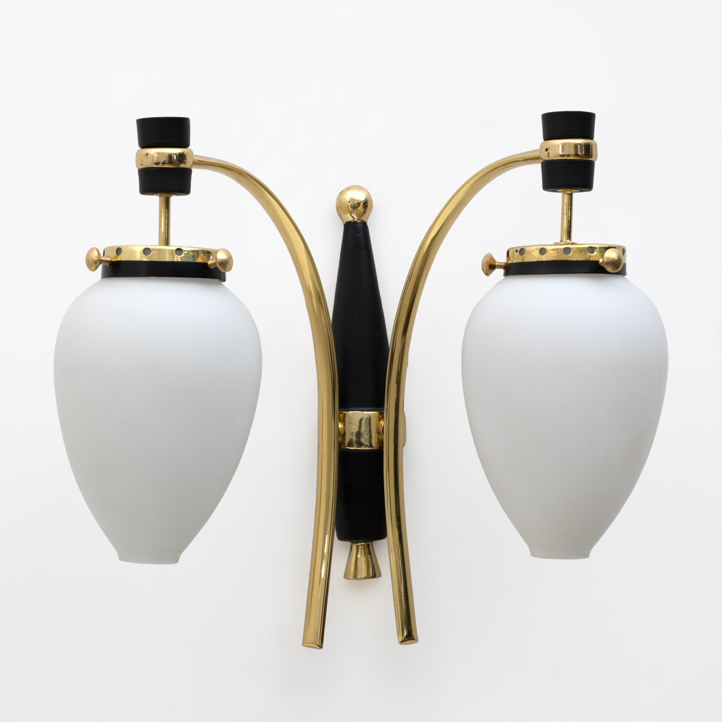 Paire d'appliques en laiton poli et laqué noir avec boîtier en verre blanc de Murano. Produit par Stilnovo en Italie dans les années 1950. Les appliques ont été entièrement restaurées, polies et recâblées pour la prise américaine E12 et la prise
