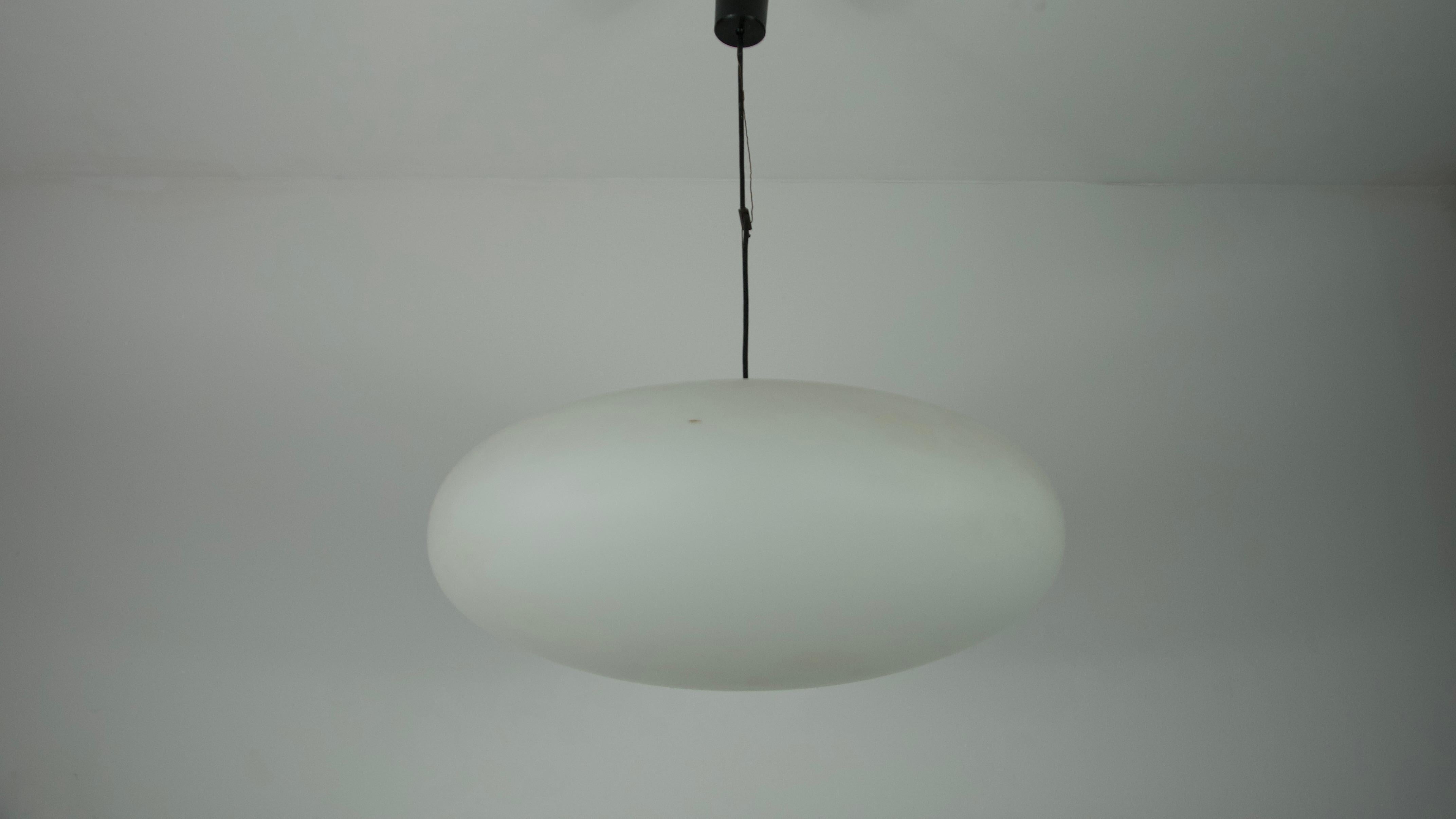 Diese moderne Deckenleuchte des renommierten italienischen Herstellers Stinero aus der Mitte des Jahrhunderts, die auf die 1950er Jahre zurückgeht, ist ein Meisterwerk von zeitloser Eleganz. Die Lampe verfügt über einen ovalen Opalglasschirm, der