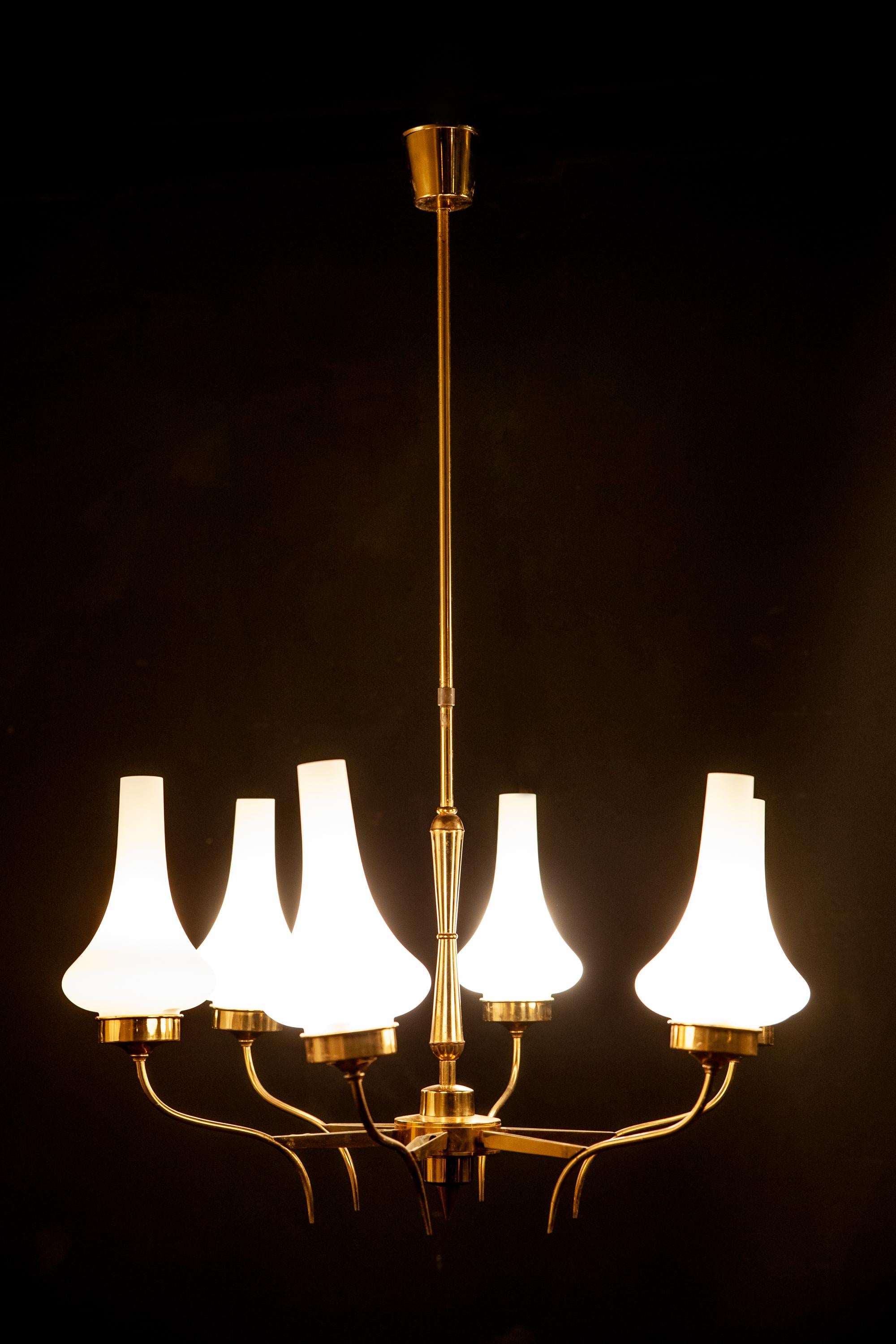 Linear elegance, brass six arm chandelier, holding upturned opaline glass shades. Excellent vintage condition.
Six E 27 light bulbs. The rod can shortened on request.
 