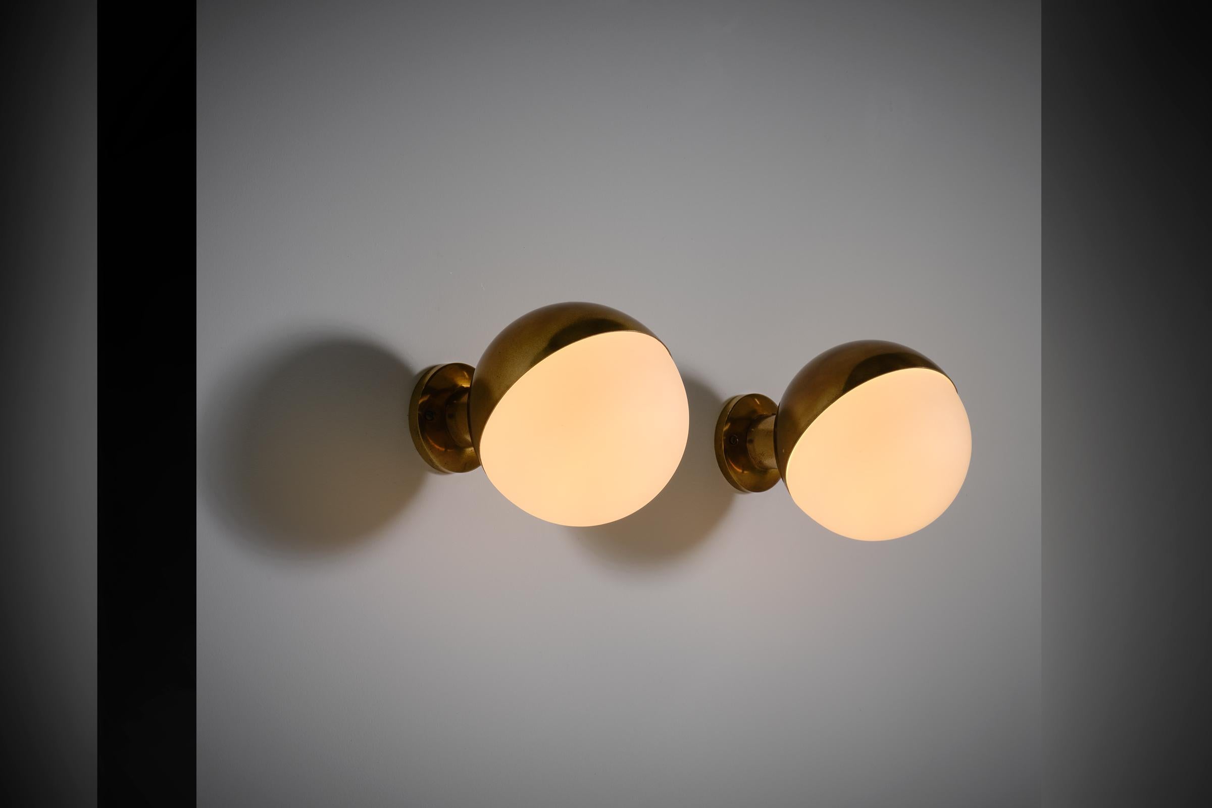 Stilnovo ‘Model 2045’ wall lamps, Italy 1950s. Beautiful design constructed out of a solid brass ball shaped fixture and matte opaline glass. The lamps produce a very nice warm and soft light due to the matte diffuser. Marked with the original