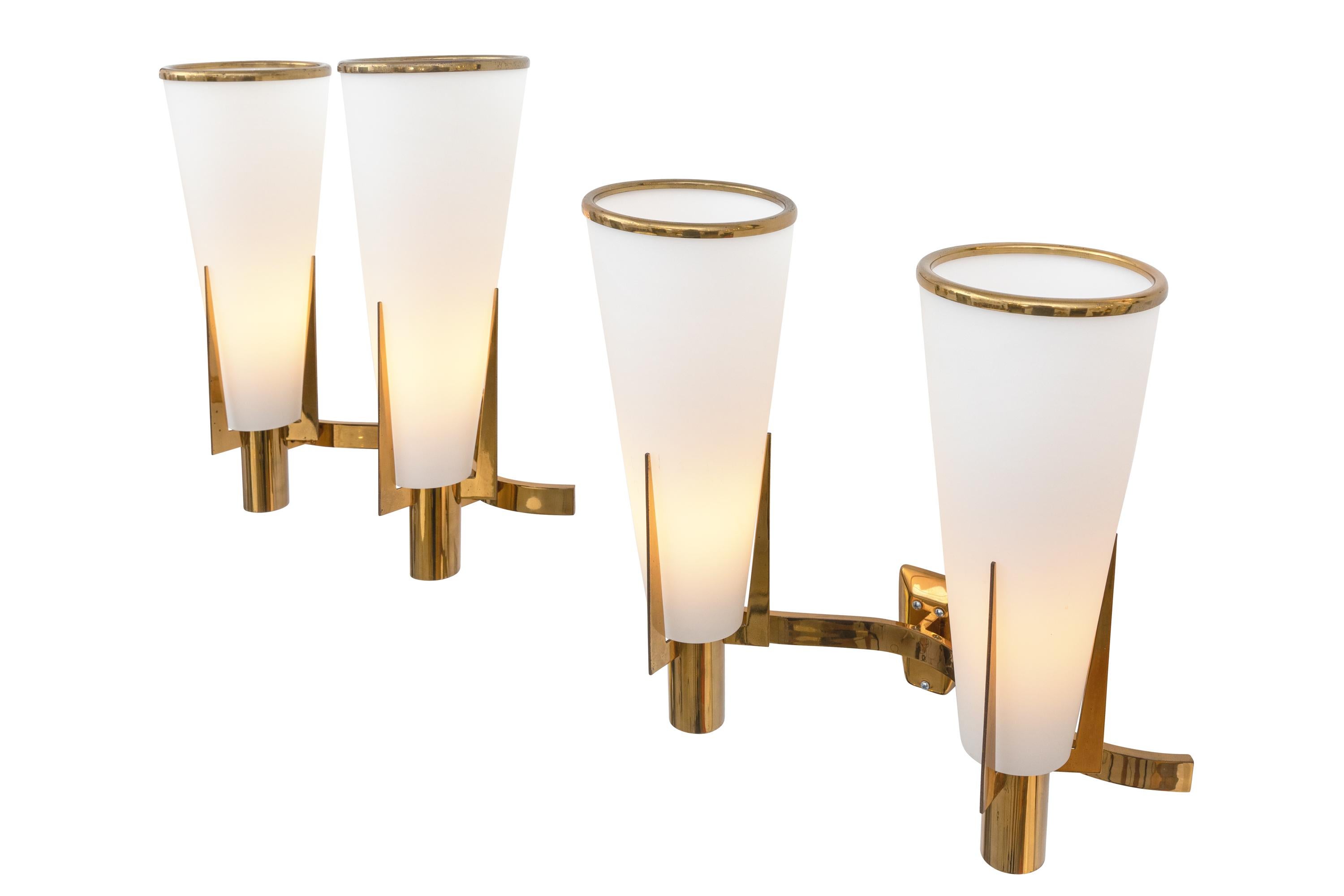 A simply elegant design and an impressive scale make these sconces a rare find, particularly in the two shade model. In original condition including the brass ring at the top of the tapered glass shade.