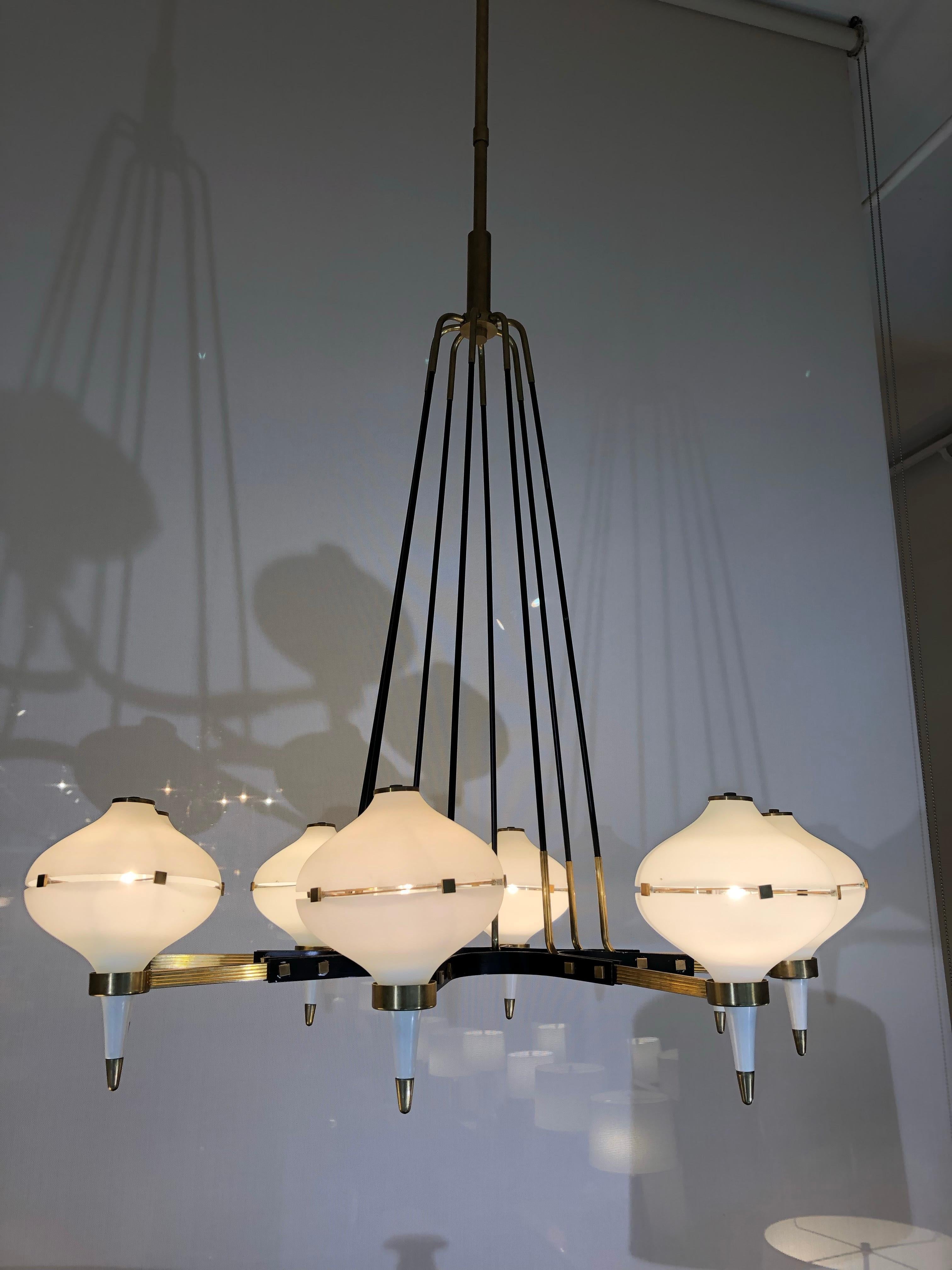 A modernist eight-light chandelier attributed to Stilnovo.
Patinated brass, black enamel and frosted glass.
Fully rewired and restored.