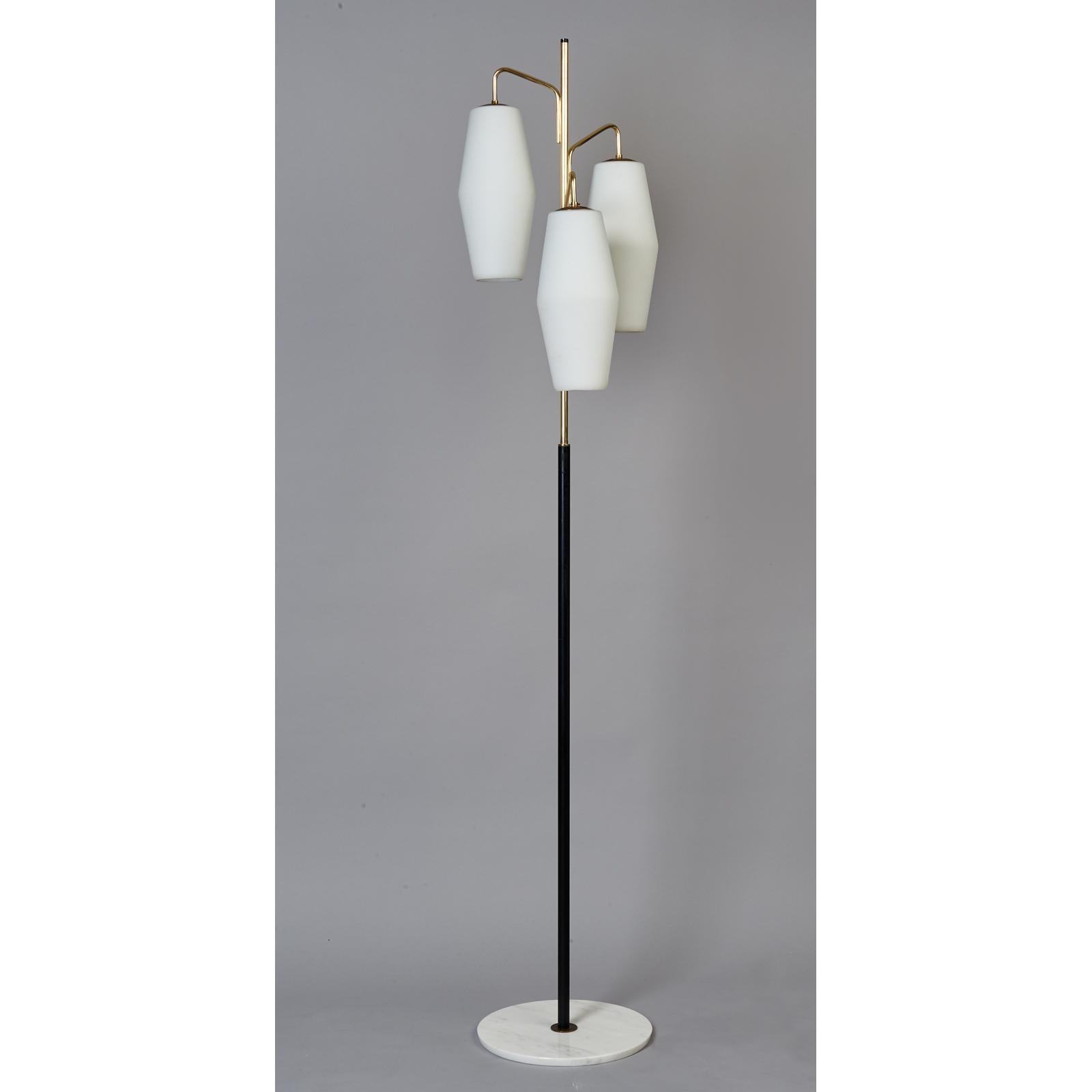 A monumental floor lamp by Stilnovo, with massive rounded hexagonal shades in thick opaline glass suspended on curved polished brass arms. The tubular black enameled shaft is anchored in a round white marble base with an elegantly angled