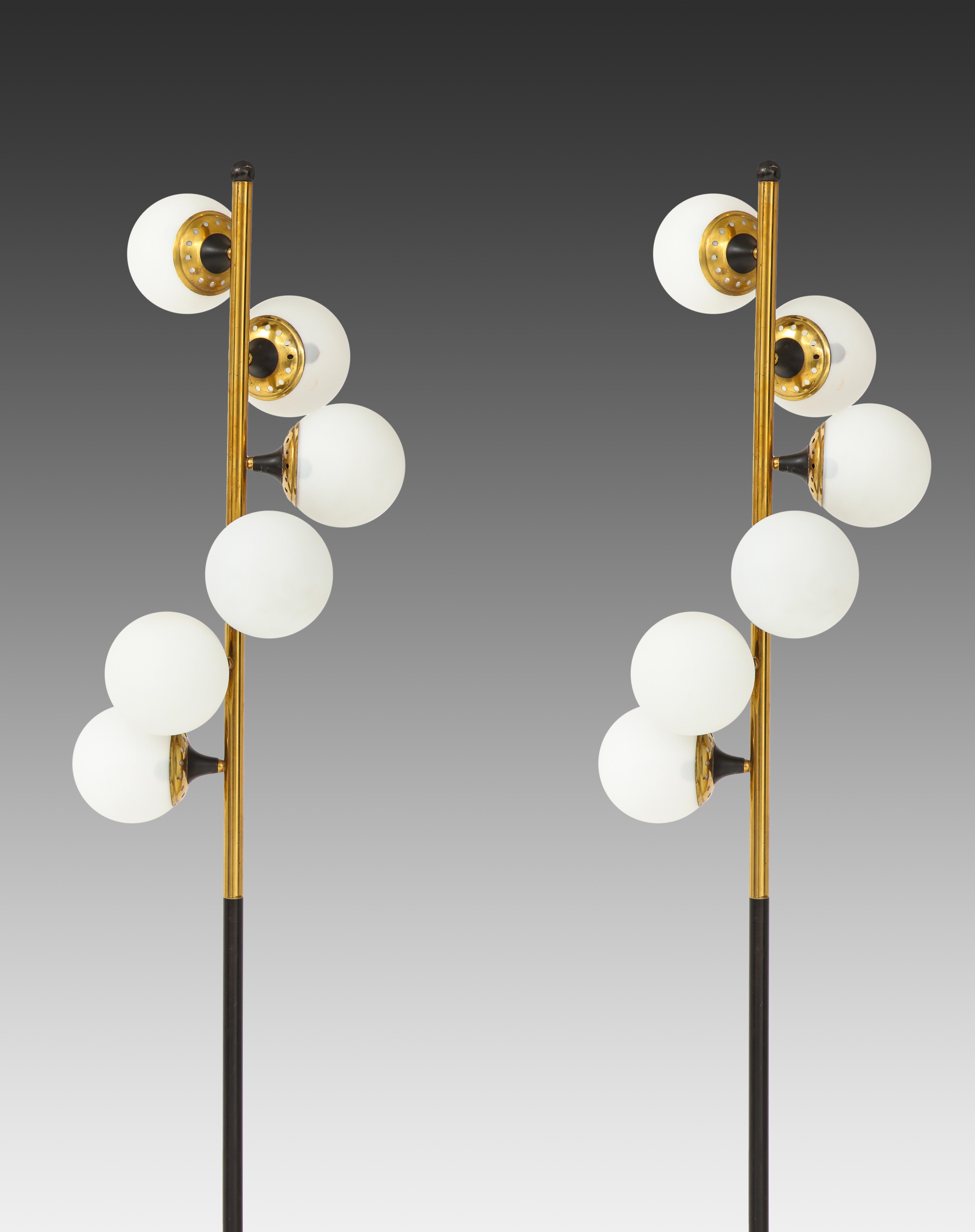Stilnovo striking pair of floor lamps each composed of six frosted opaline glass balls cascading down gilt lacquered brass and black enameled metal stem on white marble base with original foot switch. Beautiful and iconic 1950s Stilnovo design with