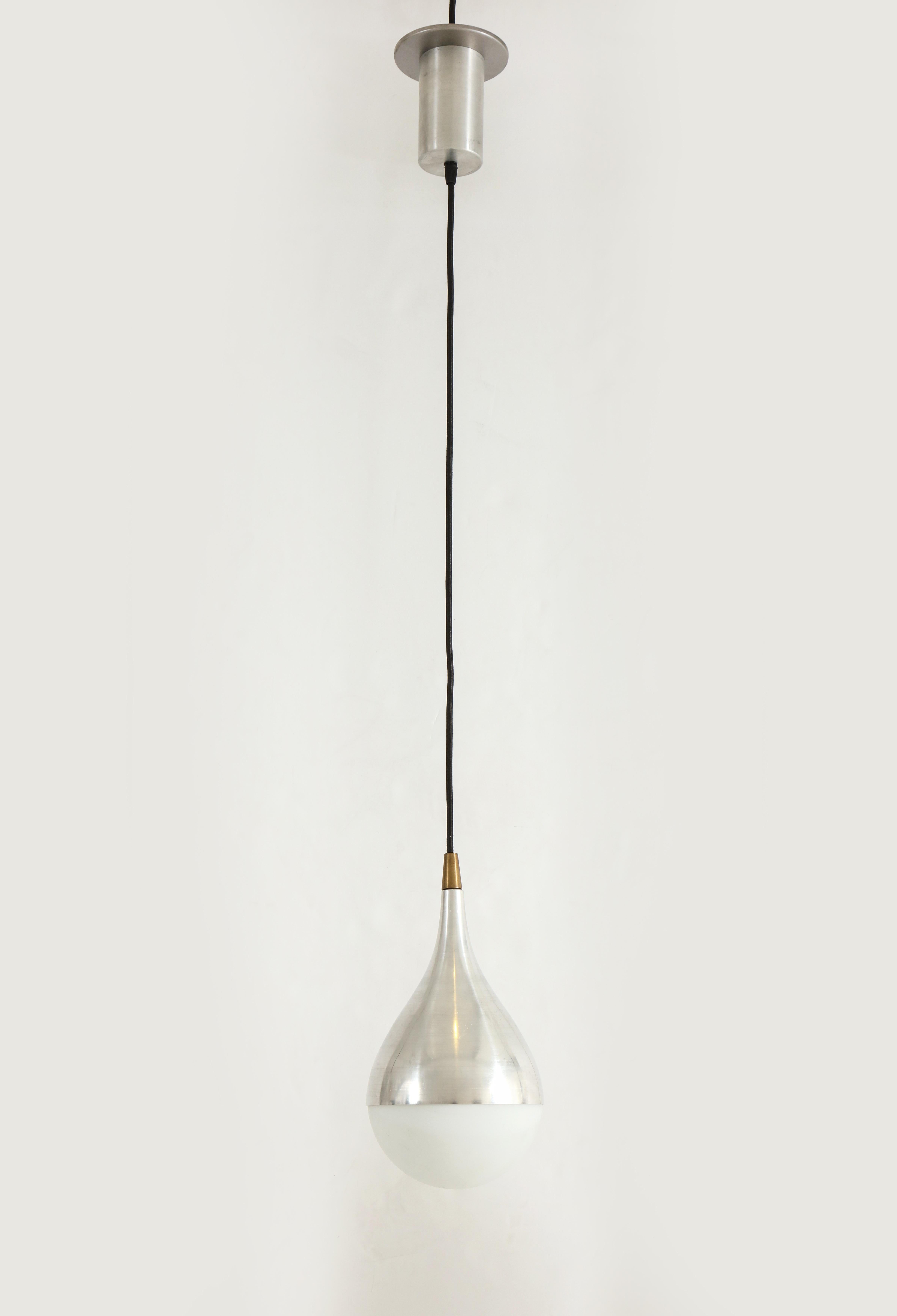 Pair of rare pendants each with opaline glass globe shades held by brushed aluminum and brass fittings suspended by cable and original brushed aluminum canopy. This iconic Stilnovo model displays an elegantly simple teardrop shape.  Its beautiful