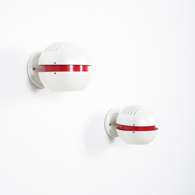 Stilnovo pearl white red globe pendant lamp, circa 1965

Beautiful vintage Italian wall lamps, aluminium sheet, enameled pearly white and red with a visor effect once illuminated. They are in good condition with no major damages and hardly to the
