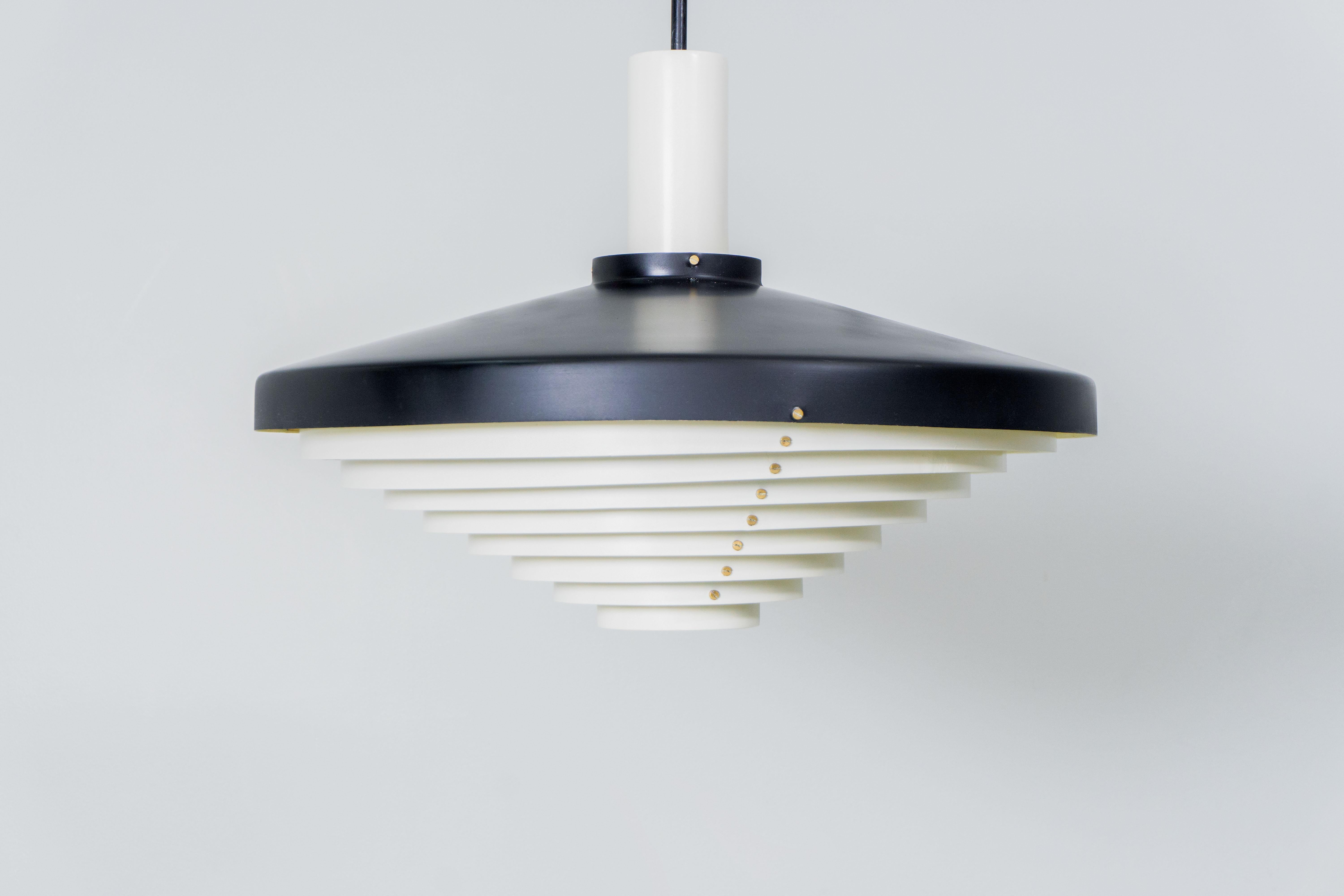 Beautiful Stilnovo Italy lamp from ca. 1955 with black and creme-enameled aluminium lamellas and a black lacquered brass rod. 

Atmospheric light effect, perfect for dining rooms and entrance halls.