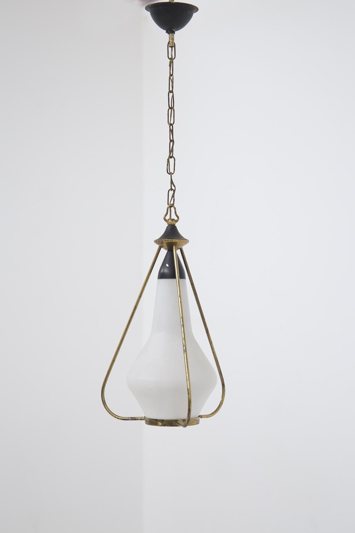 Gorgeous Stilnovo design chandelier in opaline glass and brass, made in the 1960s. The chandelier connects to the ceiling with a semicircular black aluminum element; the stem is made in the form of a gilded brass chain, which attaches to the brass