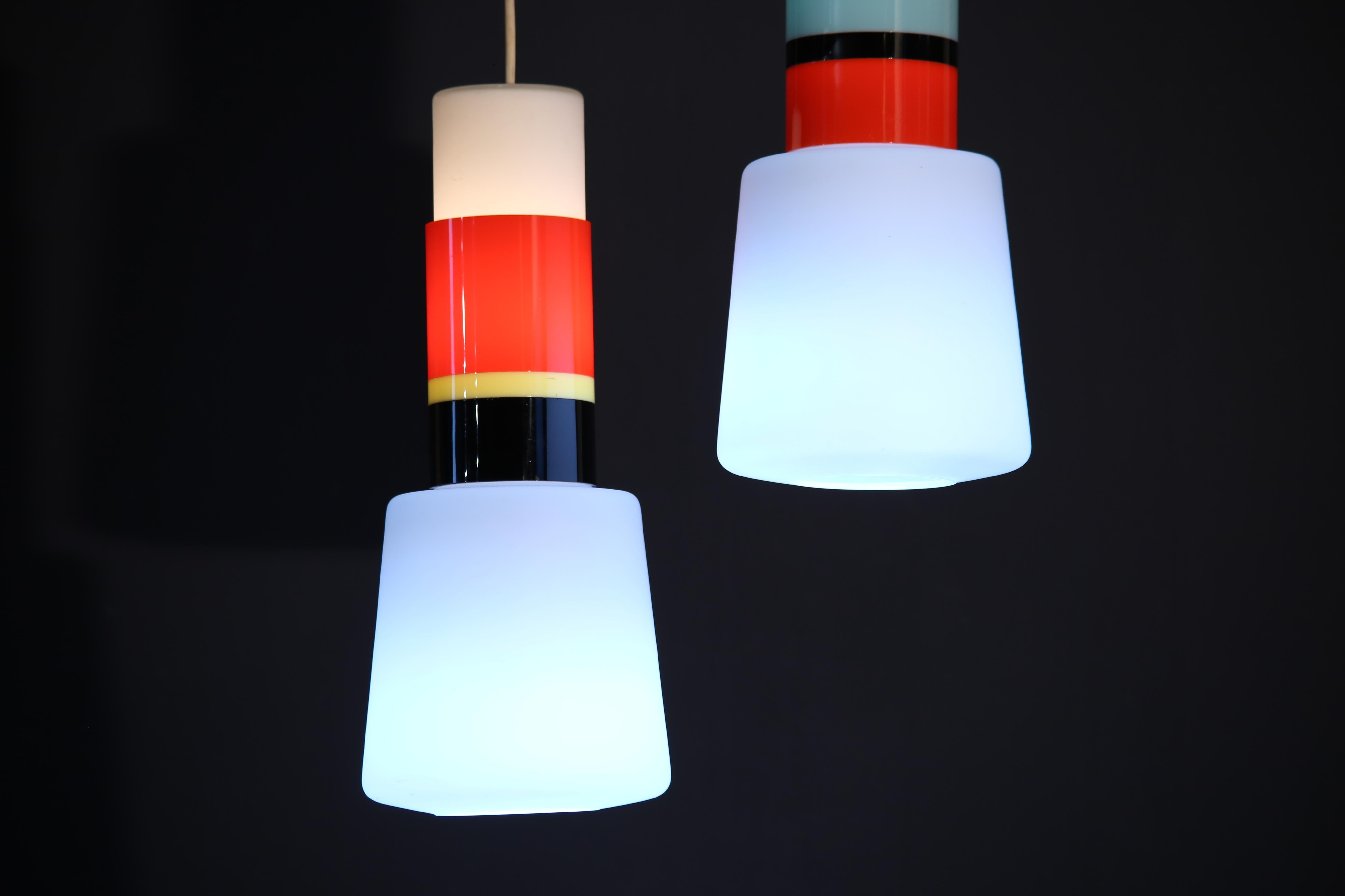 STILNOVO.
Rare pendant lamp.
Brass structure, opaline glass diffusers (double light) and colored plexiglass.
Original decal.
Stilnovo production from the 1950s