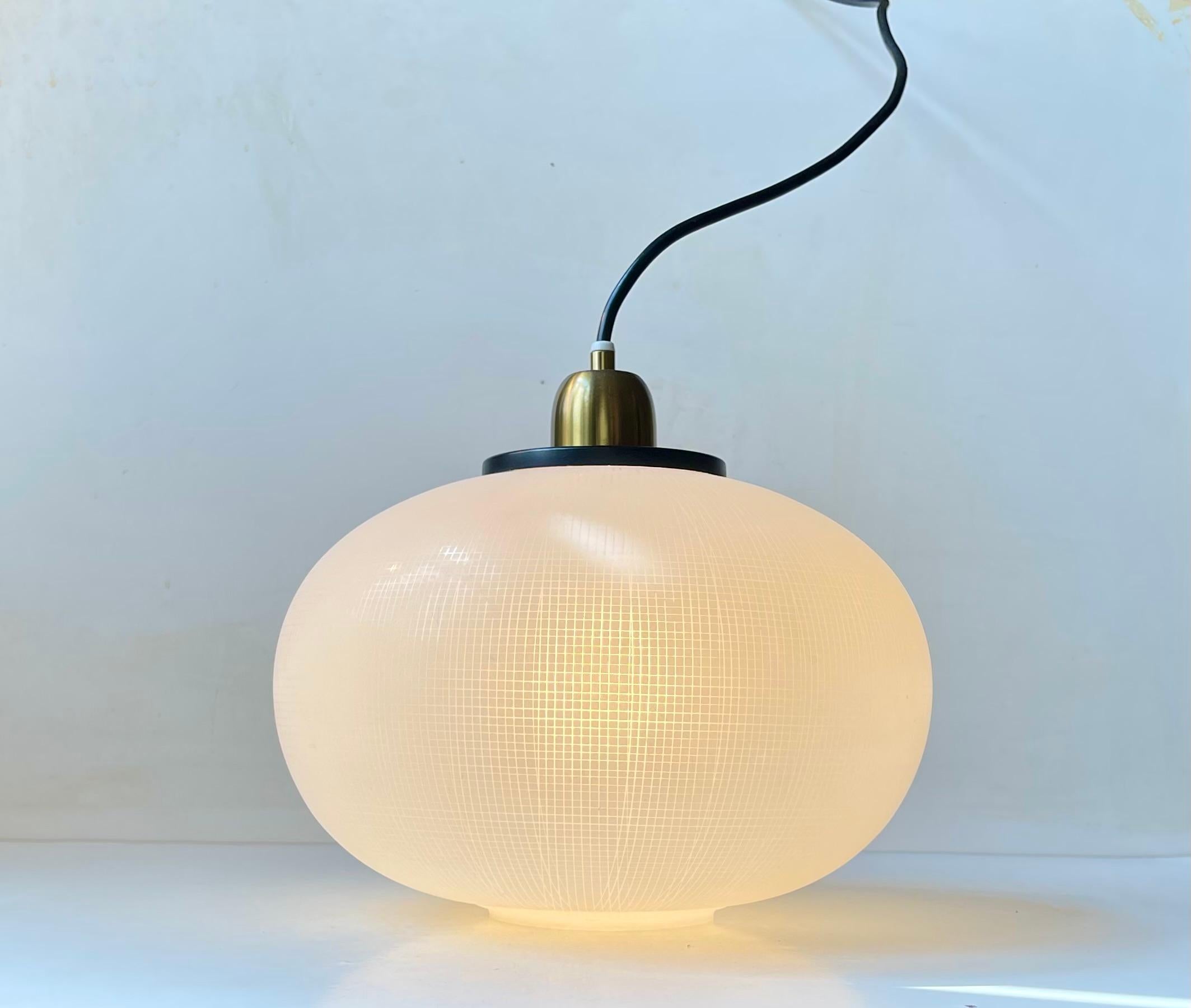 Lampada a sospensione in vetro satinato attribuita a Stilnovo, Italia, anni 1950-60. Eleganza nella cupola di vetro soffiato a mano inciso verticalmente e incastonato in un piano nero accentuato dall'ottone. Abbiamo ricablato questo pezzo e lo