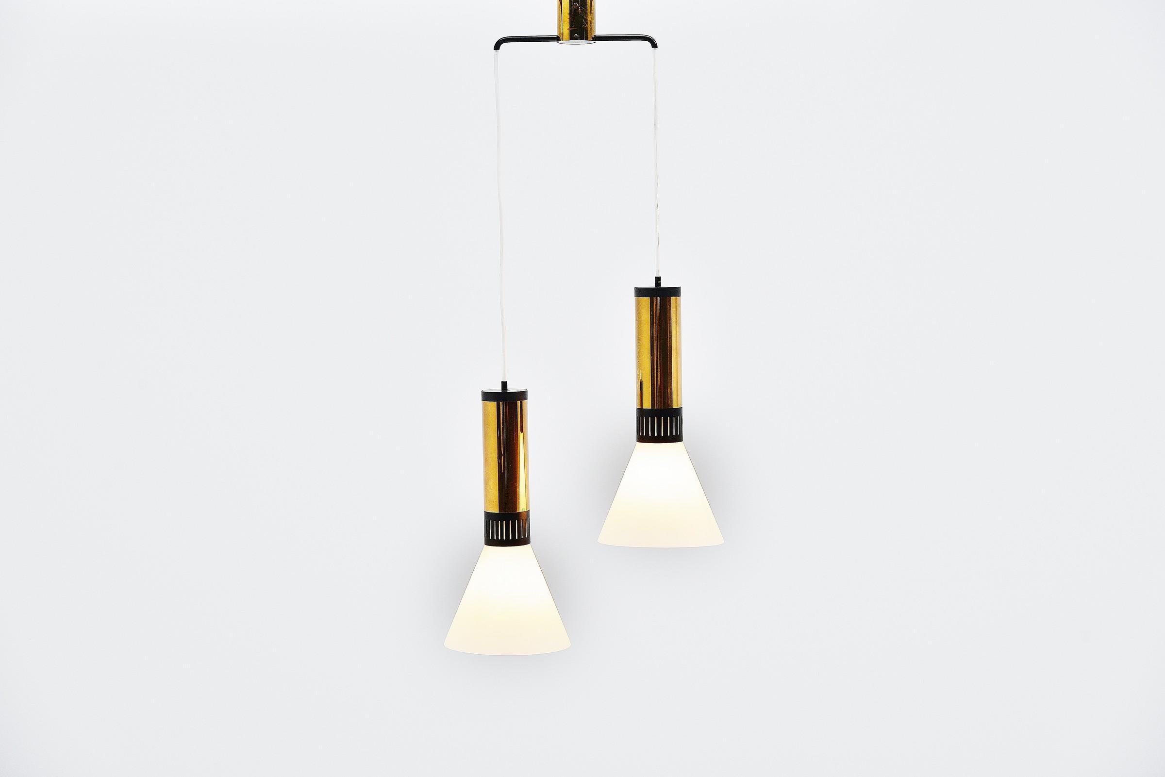 Very nice double pendant lamp model 1135 with nice shaped ceiling fitting for 2 pendants, designed and manufactured by Stilnovo, Italy 1960. This lamp has fittings made of brass and black painted metal tubes, with die cut strip pattern for a nice