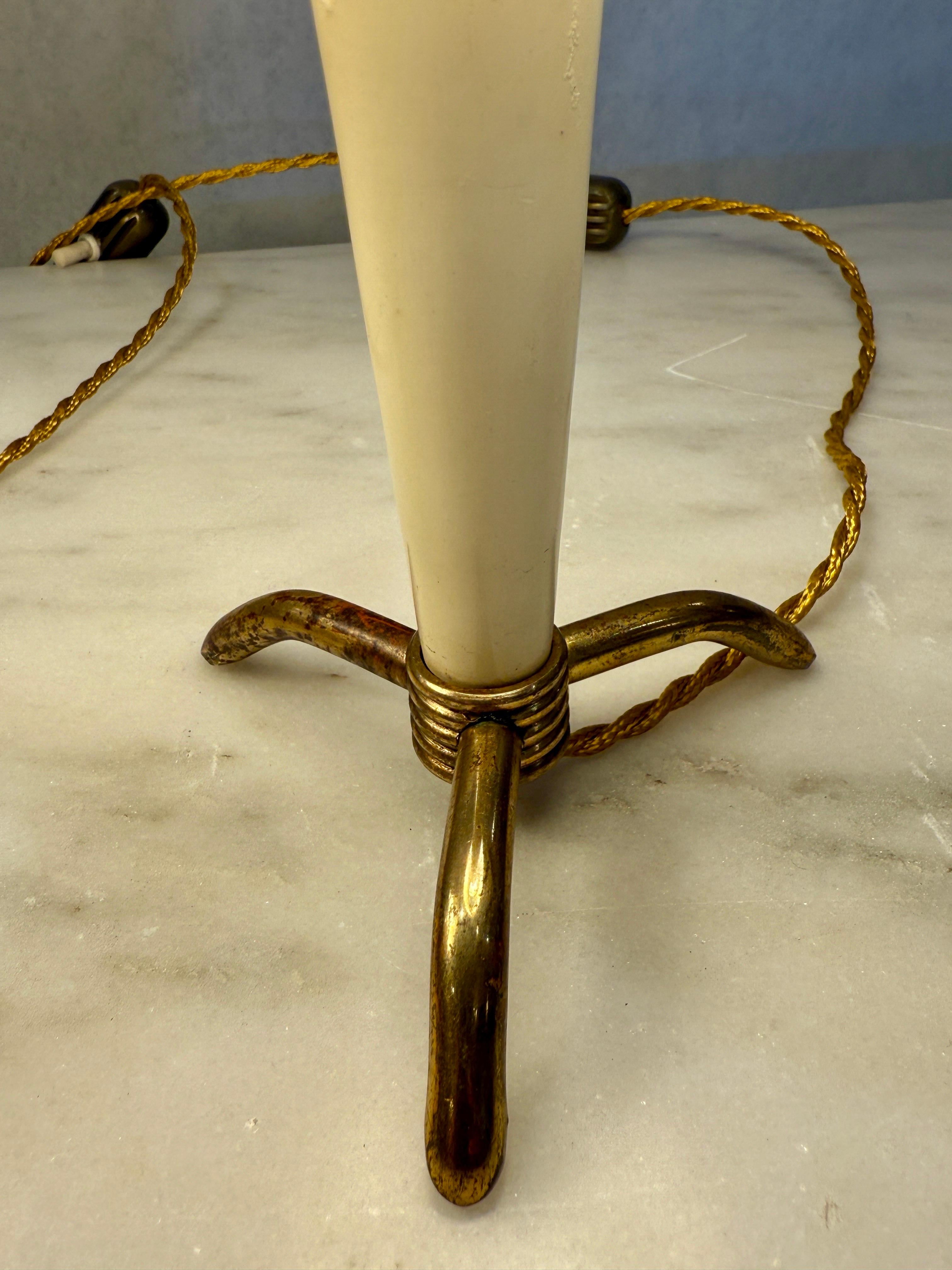 Attributed to Stilnovo, these lovely petite lamps are so cute and burst of personality - they would fit perfectly on a bookshelf, library, boudoir, kids room, etc.  They have a tripod brass base and original painted yellow and cream tapering bodies.