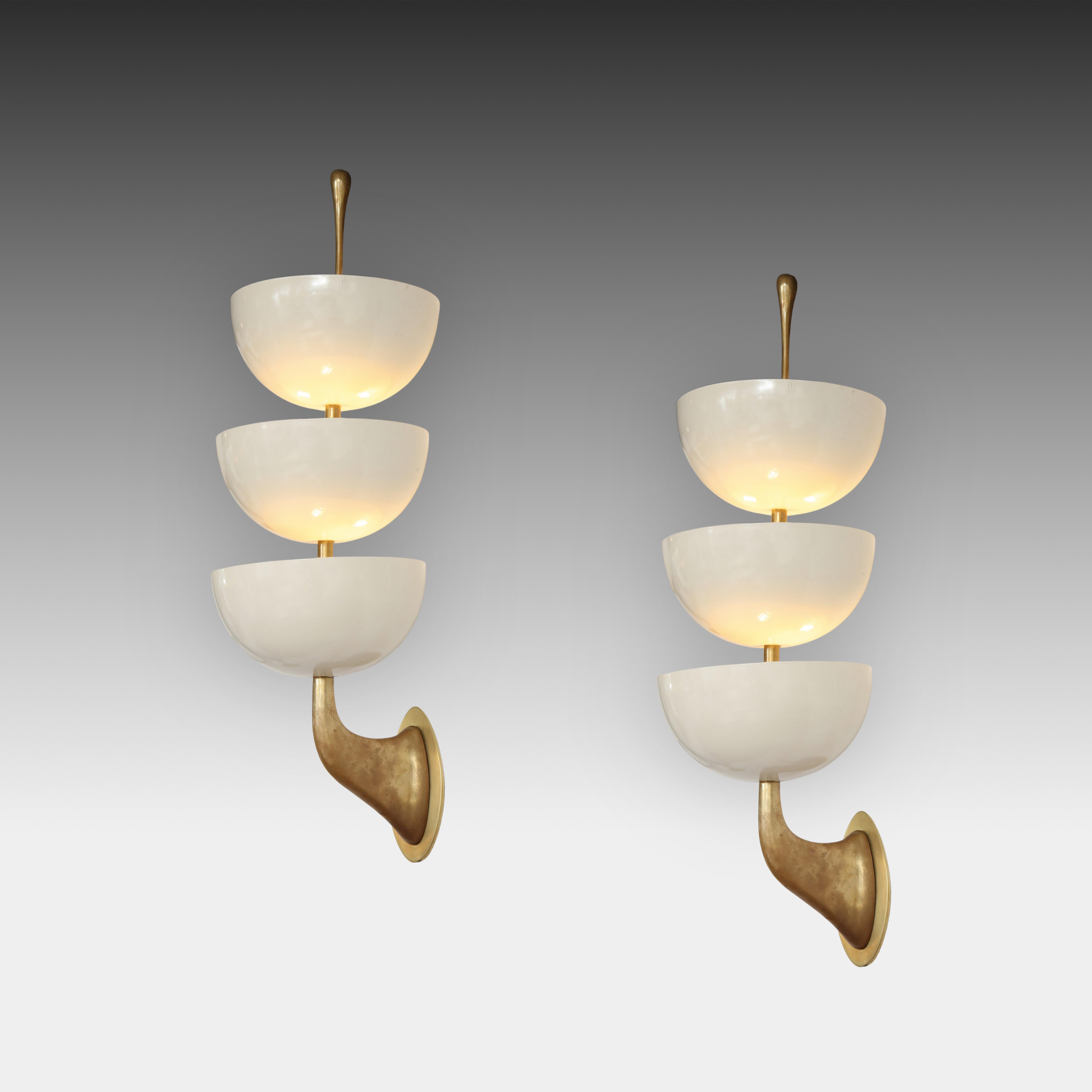 Stilnovo rare original and exquisite pair of sconces with three eggshell white lacquered metal cups mounted on gilt lacquered brass structure, Italy, circa 1952. Stamped 'STILNOVO' on finials. 
Rewired to U.S. standards with UL listing and custom