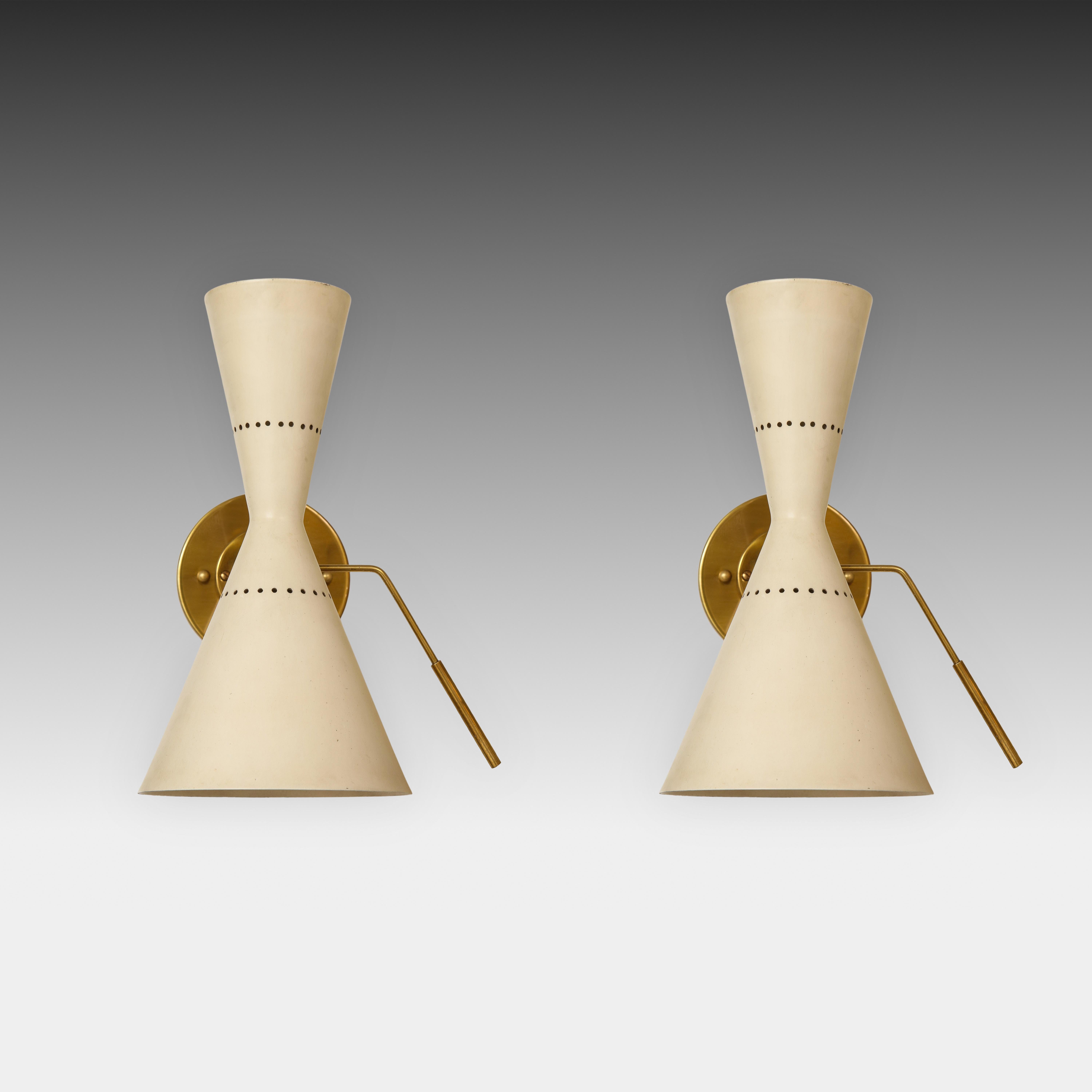 Stilnovo rare pair of adjustable articulating two-light cone-shaped sconces or wall lights with cream lacquered perforated metal shades which pivot with brass handles, and attached to original backplates. The cream shades each hold a socket on each