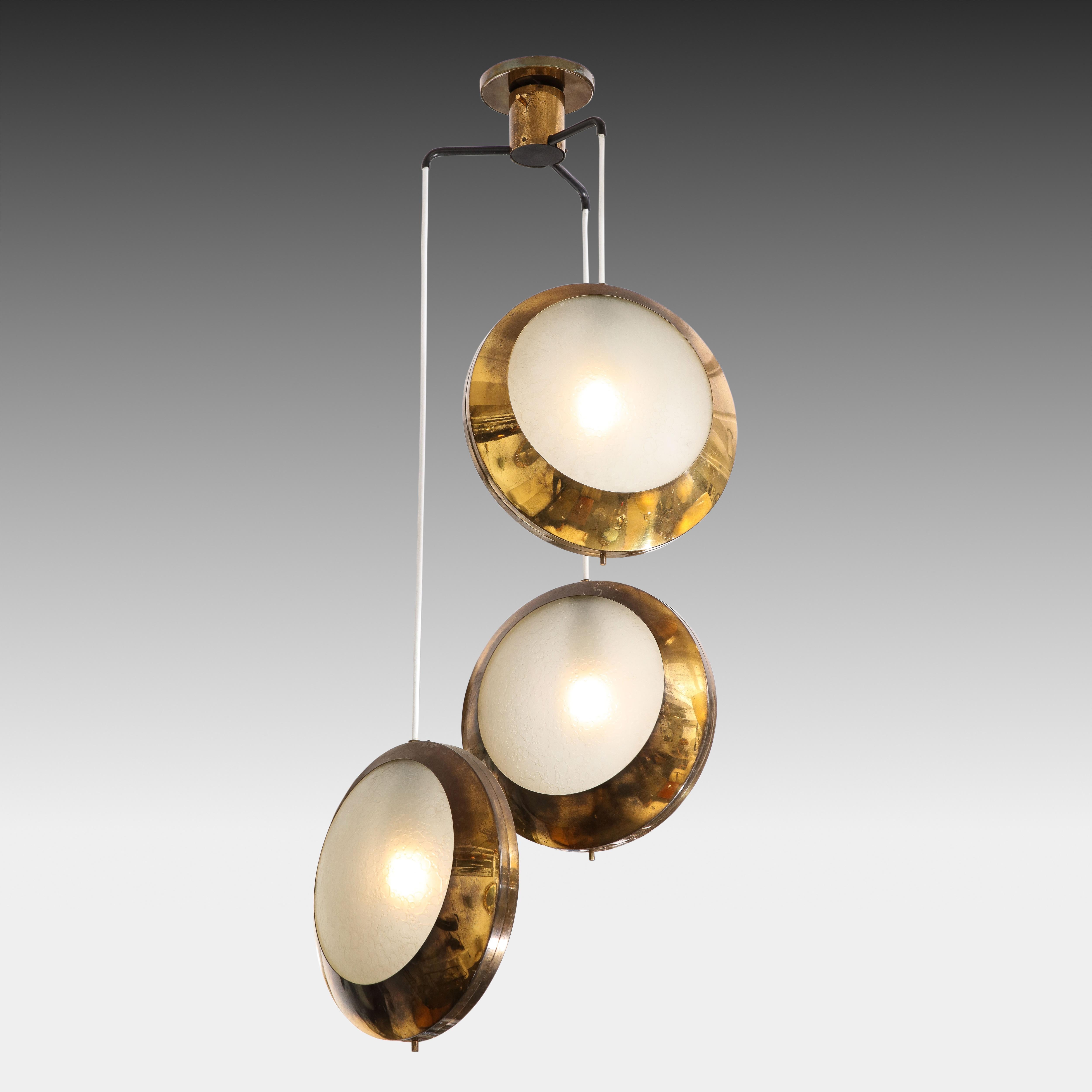 Stilnovo rare pendant light or chandelier model 1205 with three shades made of brass with textured acid-etched glass diffusers at alternating heights suspended from original canopy, Italy 1950s. This pendant light is simple yet striking and