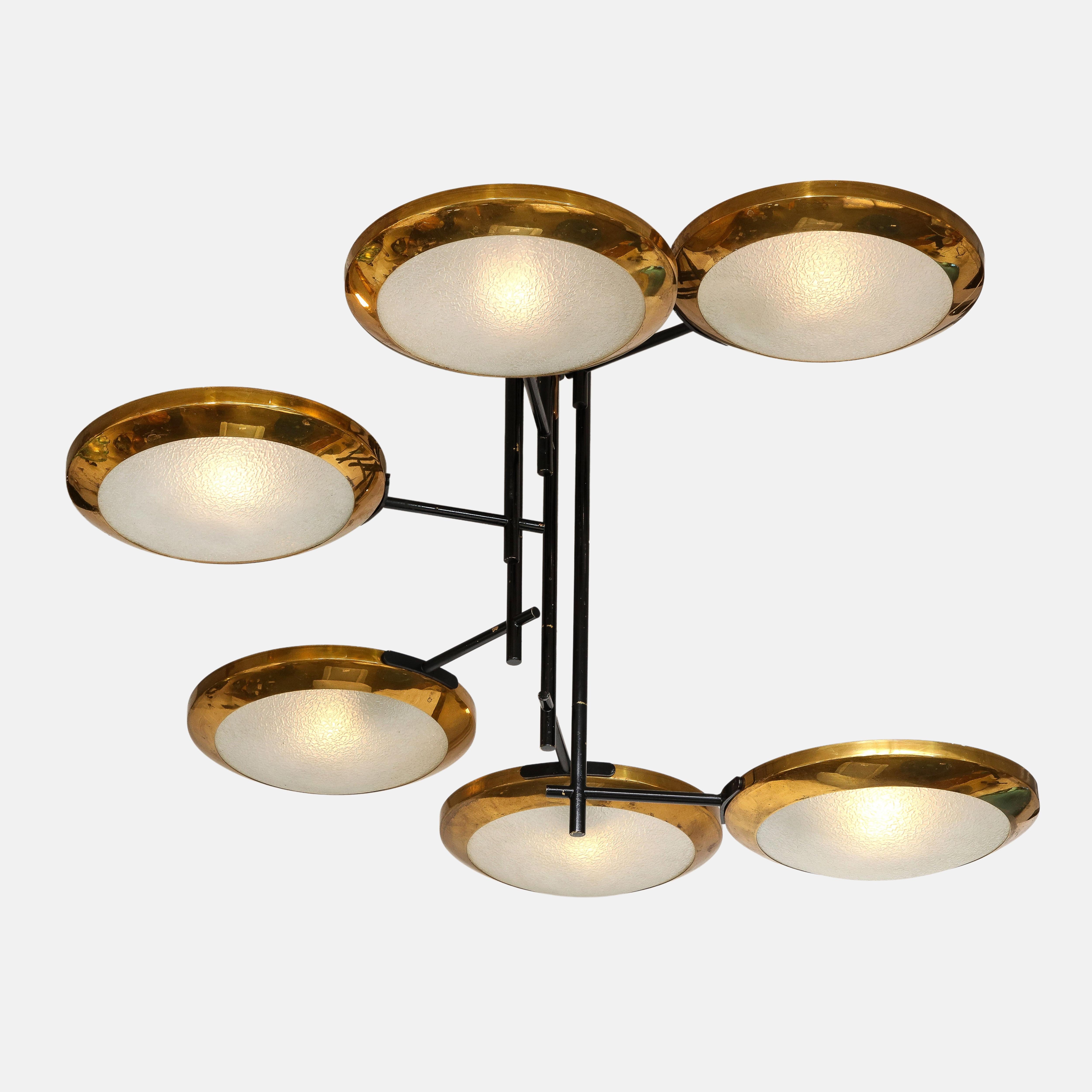 Stilnovo rare chandelier consisting of six circular brass framed lights with textured acid-etched glass diffusers suspended at alternating heights from three black-painted stems or enameled steel rods with original canopy, Italy, 1950s.  This chic