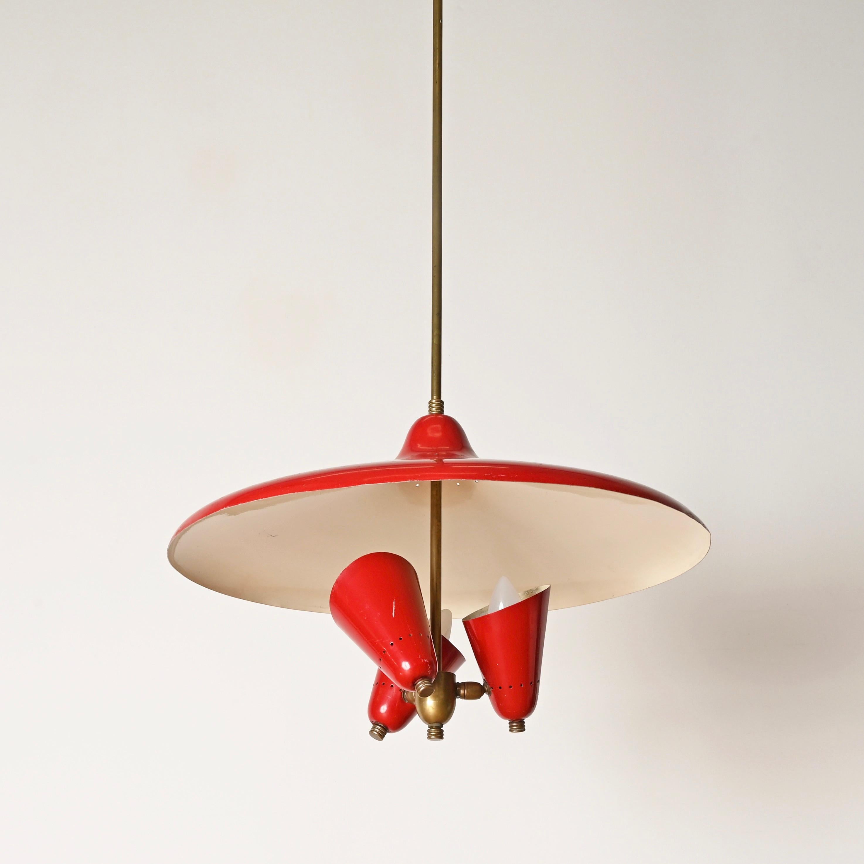 Stunning three light chandelier in red enameled metal and brass. This elegant and unique piece was designed by Stilnovo and produced in Italy during the 1950s.

Fully original and in fabulous vintage condition. The chandelier features a round red