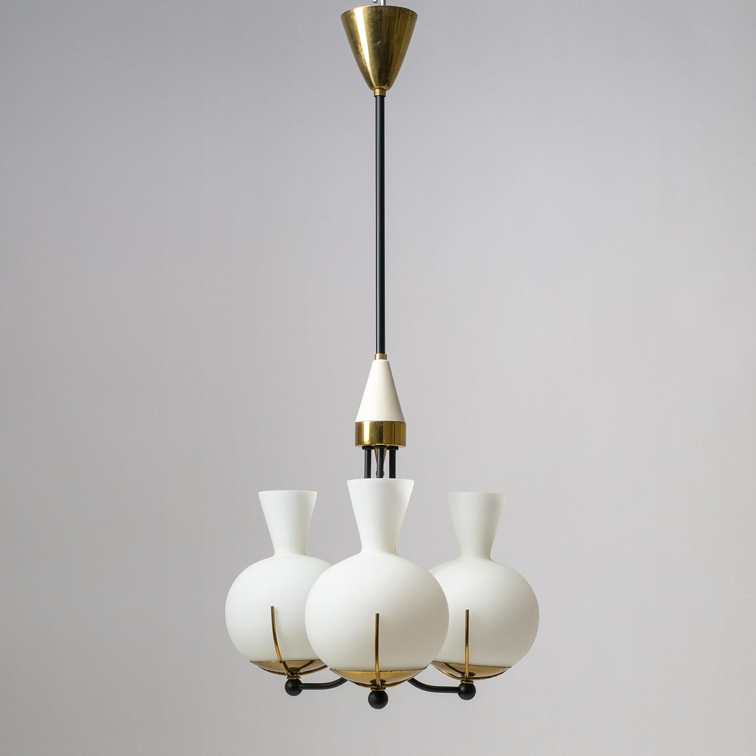 Lovely three-globe chandelier by Stilnovo from the 1950s. Stylized pomegranate satin glass diffusers sit atop brass hardware and black lacquered stems. Very nice original condition with a light patina on the brass and minor wear to the lacquer. One