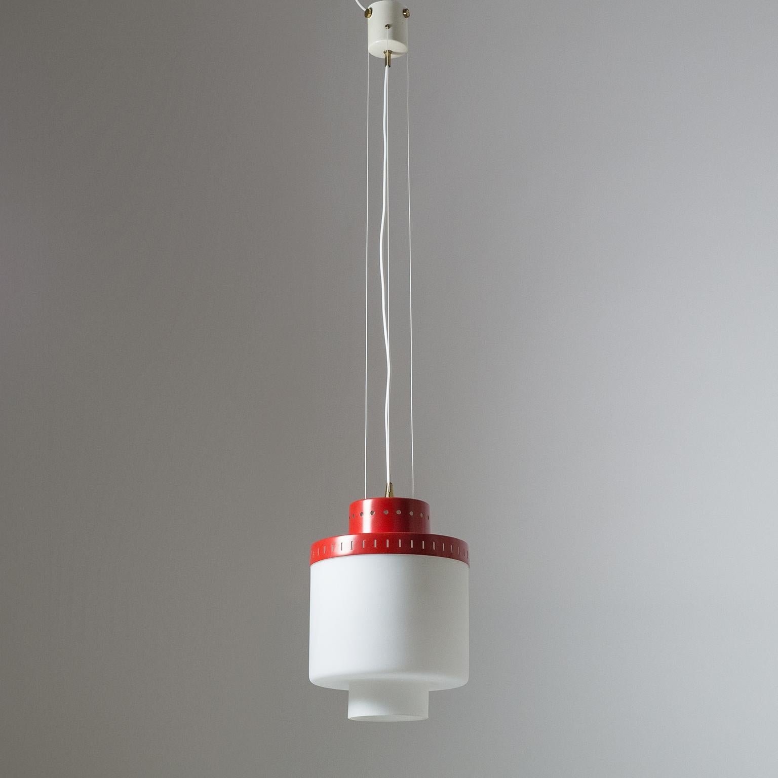 Rare Stilnovo suspension light from the early 1950s. A cylindrical, tiered satin glass diffuser with a red lacquered and pierced aluminum shade is suspended by three nylon wires. Very good original condition with minor loss of original paint and a