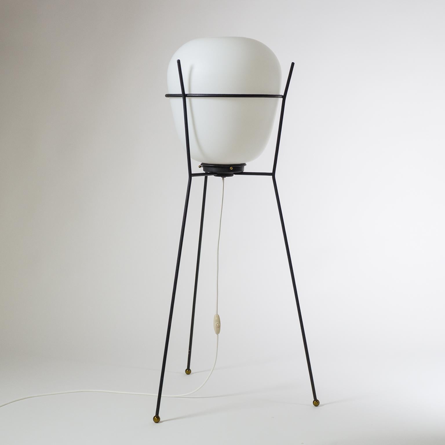 Modernist Stilnovo tripod floor lamp 1950s. A sculptural minimalist blackened steel structure with brass details holds a large oval satin glass (triplex opal) diffuser. One original brass and ceramic E27 socket with new wiring.