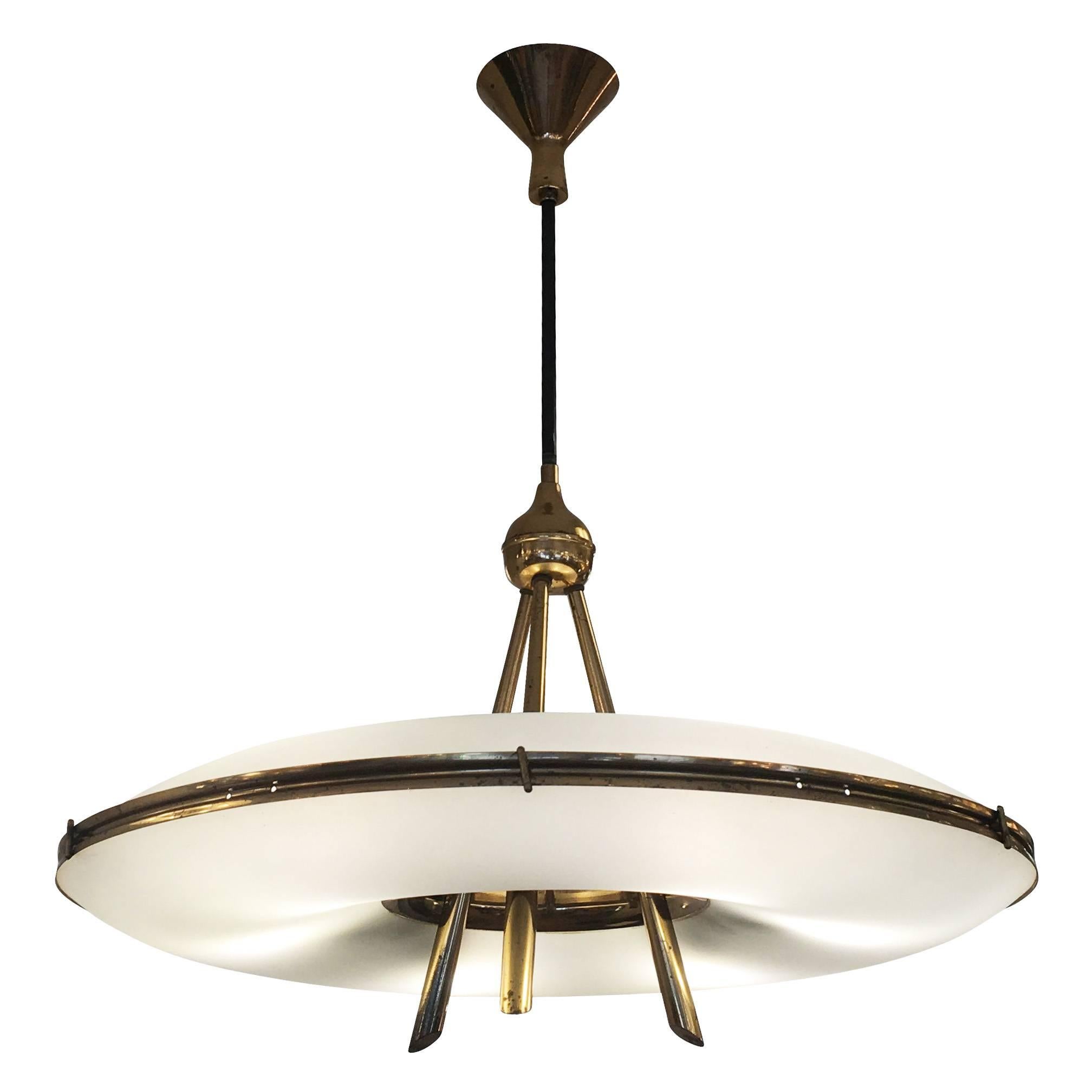 Saucer shaped chandelier in the style of Stilnovo with two frosted glass shades on a brass frame. The architectural and well thought out design is highlighted by the three stems that merge into one and the contoured canopy. Holds six candelabra