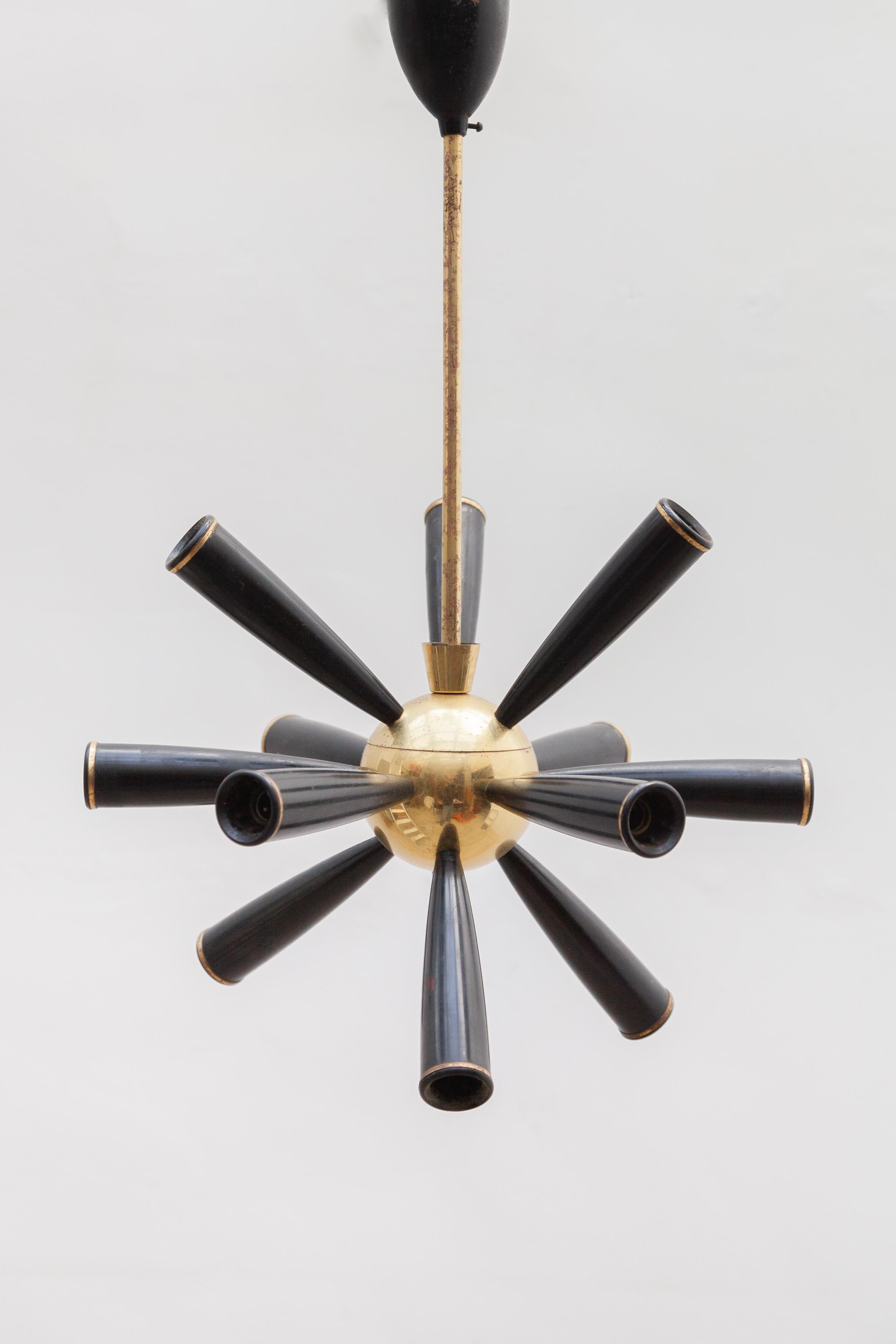1950s excellent massive Sputnik chandelier attributed to Stilnovo with a brass frame and 12 metal black lacquered shades lights. In addition to the arms with bulbs giving this chandelier a very dynamic 'star burst' quality. Very nice original